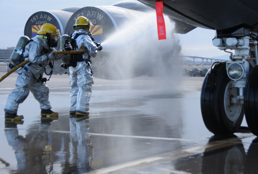 Firefighters from the 161st Air Refueling Wing set up a ladder and prepare to make entry into an aircraft as part of simulated egress exercise July 10, 2011. Communication and safety are key factors that firefighters aim to prefect during training exercise. (U.S. Air Force Photo by Staff Sgt. Courtney Enos/Released)