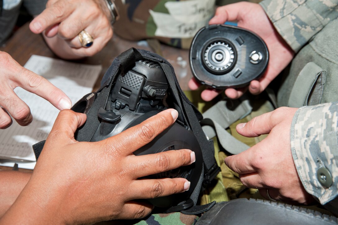 Members of the 81st Computer Science Corporation, a civilian contractor with the 81st Training Wing, check for serial numbers on the gas mask for Tech. Sgt. Joel Wilson, 41st Aerial Port Squadron air transportation craftsman. 403rd Wing members processed through the simulated passenger terminal during the pre-deployment portion of the Readiness Assistance Visit 2 held during the July unit training assembly. 81st CSC members took inventory of the training gear issued to 403rd WG members and ensured their mobility folders had accurate documentation. (U.S. Air Force photo/Tech. Sgt. Ryan Labadens)