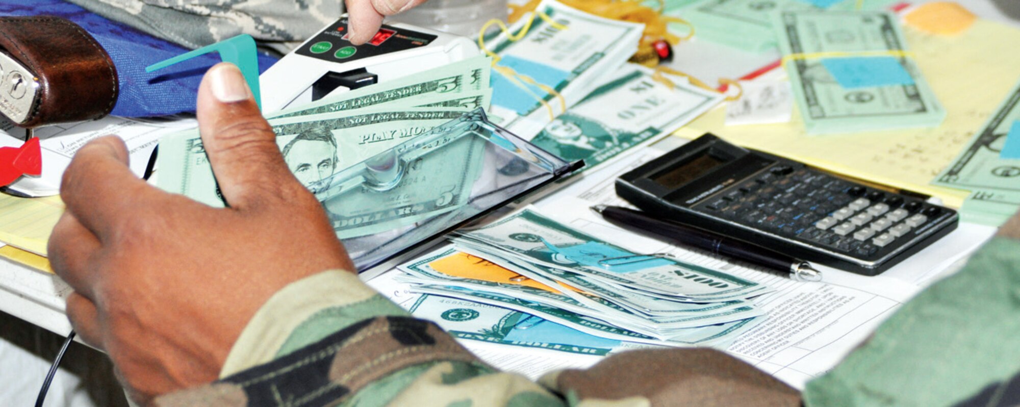 Master Sgt. Kyle Fortson, 452 AMW/FM unit training manager and member of Team B, uses an electronic portable bill counter to ensure all cash in the office is accounted for, which is done at the start and end of each shift to balance the register. When deployed, teams are also responsible for making local bank runs to acquire cash and then safeguarding it and distributing it to customers. (U.S. Air Force photo by Megan Crusher)
