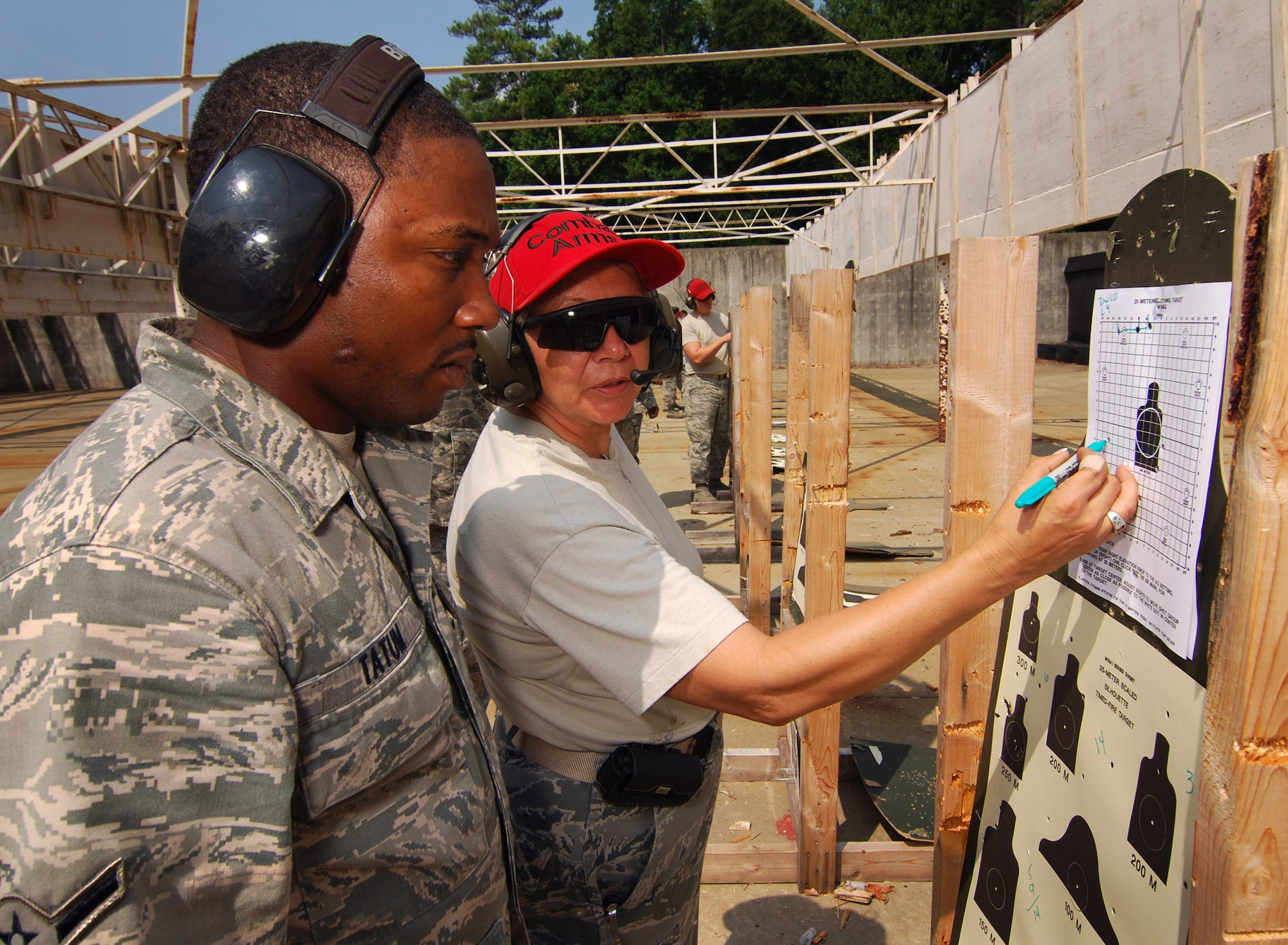 Airman Clarence Tatum, 94th Security Forces Squadron, receives M-4 carbine sight correction instructions from Master Sgt. Elaine Bowman, also from the 94th Security Forces Squadron, at Dobbins Air Reserve Base during the monthly Unit Training Assembly, July 9.  94th Security Forces Combat Arms Training and Maintenance instructors conduct the training with several hours of classroom and firing range instruction ending with a qualification course of fire.  (U.S. Air Force photo/ Brad Fallin)