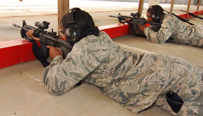 Airman 1st Class Jessica Nowell and Airman Clarence Tatum, both from the 94th Security Forces Squadron, shoot to qualify on the M-4 carbine at Dobbins Air Reserve Base during the monthly Unit Training Assembly, July 9.  94th Security Forces Combat Arms Training and Maintenance instructors conduct the training with several hours of classroom and firing range instruction ending with a qualification course of fire.  (U.S. Air Force photo/ Brad Fallin)
