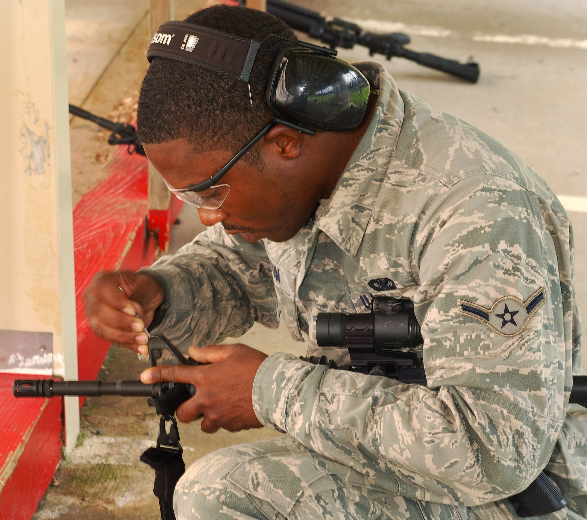 Airman Clarence Tatum, 94th Security Forces Squadron, makes front sight corrections on an M-4 carbine at Dobbins Air Reserve Base during the monthly Unit Training Assembly, July 9.  94th Security Forces Combat Arms Training and Maintenance instructors conduct the training with several hours of classroom and firing range instruction ending with a qualification course of fire.  (U.S. Air Force photo/ Brad Fallin)