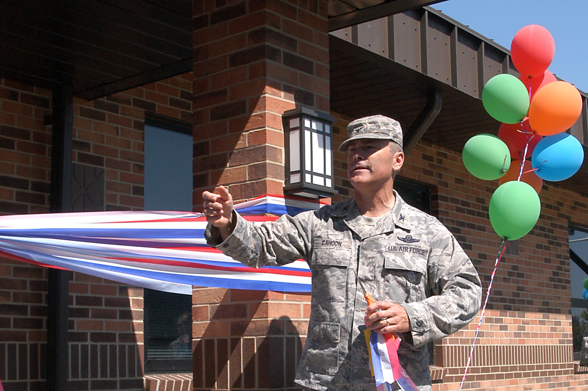 GRISSOM AIR RESERVE BASE, Ind. -- Col. William T. ?Tim? Cahoon, 434th Air Refueling Wing commander, gathers people around the new Airman and Family Readiness Center building here before taking part in a ribbon cutting July 9. The new building provides more space for Airmen and their family members. It also houses the 434th Seasoning Training Flight, the sexual assault response coordinator, newcomers flight, the 434th ARW chaplain?s office and maintenance supply liaison office. (U.S. Air Force photo/Senior Airman Damon Kasberg)                   