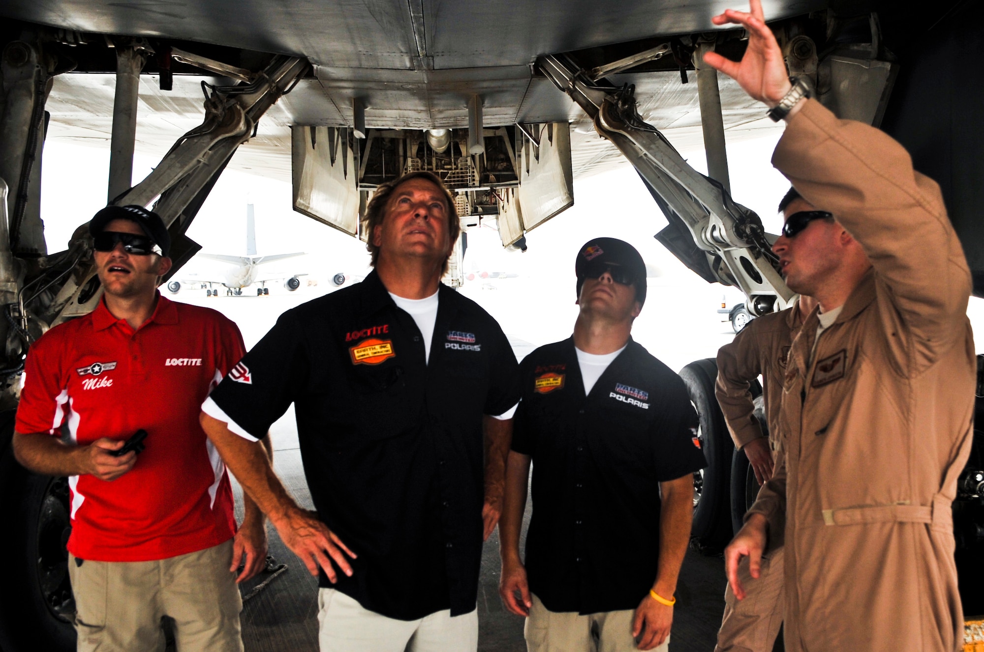Mike Schultz, three-time ESPN X Games gold medal winner, Glen Kafka, crew chief to Levi LaVallee, and Levi LaVallee, seven-time ESPN X Games gold medal winner tour the 379th Air Expeditionary Wing’s flight line, July 10, at an undisclosed location in Southwest Asia. LaVallee and Schultz were part of the Armed Forces Entertainment  'xHEAVY Medal Tour.’ (U.S. Air Force photo/Senior Airman Paul Labbe)