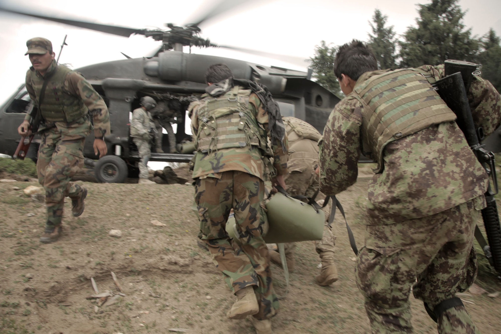 BAGRAM AIRFIELD, Afghanistan -- U.S. Army soldiers from D Company, 2nd Battalion, 35th Infantry Regiment, alongside the Afghanistan National Army soldiers, medically evacuate wounded civilians after a fire fight during Operation Hammer Down in the Watahpur District of Kunar province, Afghanistan, June 26. The operation was a coalition effort to disrupt insurgents operating and training throughout the Pech Valley. (U.S. Army photo by Spc. Tia Sokimson)