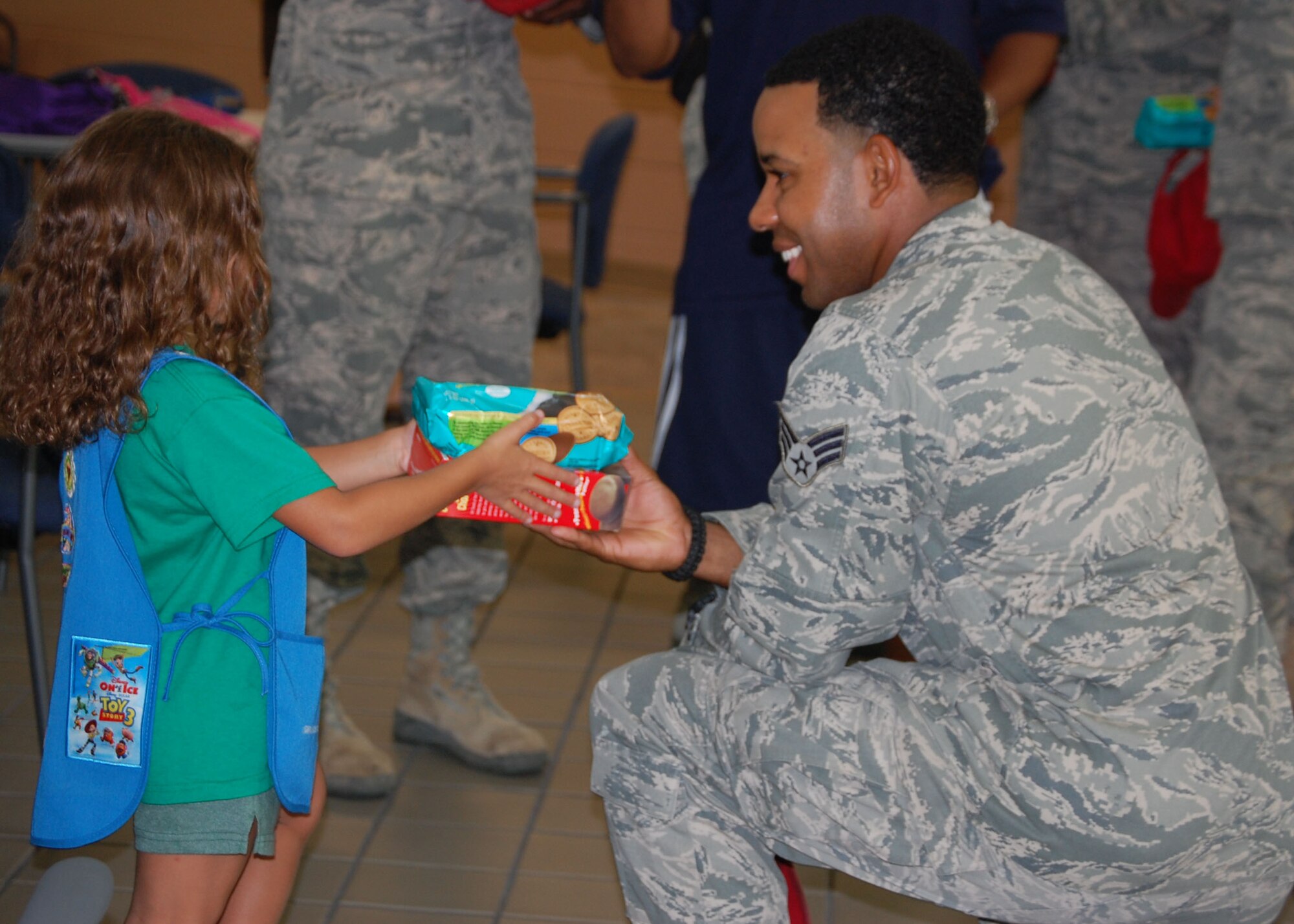 A Reservist with the 567th RED HORSE Squadron receives cookies from a Girl Scout on Sat. July 9. More than 60 Girl Scouts visited Airmen preparing to deploy overseas. (USAF photo by Donna Lea, 916ARW/PA)