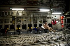 Staff Sgt. Steven Holman, 816th Expeditionary Airlift Squadron loadmaster, checks his watch while on the final leg of a 15-hour air drop mission on a C-17 Globemaster III July 8, 2011. During the mission, Holman and the crew airdropped a total of 73,200 pounds of fuel and 48,000 pounds of Meals, Ready to Eat to resupply forces on the ground in Afghanistan. (U.S. Air Force photo/Master Sgt. Jeffrey Allen)