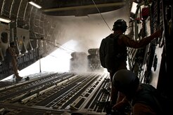 Staff Sgts. Russell Johnson (right) and Stephen Adams, 816th Expeditionary Airlift Squadron loadmasters, watch as 20 bundles of JP8 fuel barrels are airdropped to ground forces from a C-17 Globemaster III July 8, 2011. The crew airdropped a total of 73,200 pounds of fuel to resupply forces on the ground in Afghanistan. It was one of two re-supply airdrop missions flown by the crew that day. (U.S. Air Force photo/Master Sgt. Jeffrey Allen)