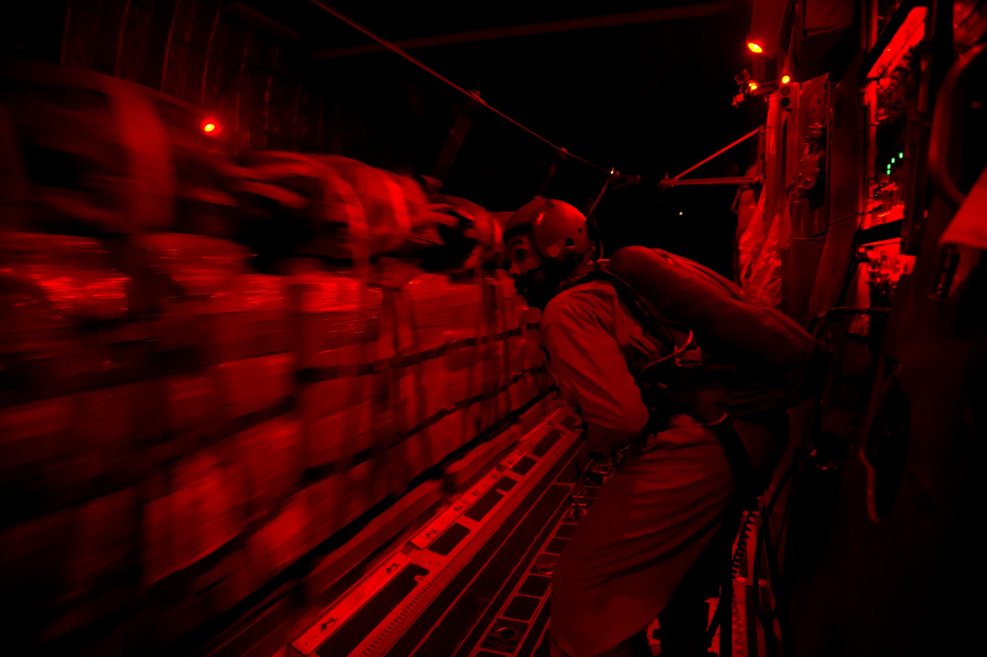 Staff Sgt. Stephen Adams, 816th Expeditionary Airlift Squadron loadmaster, releases 48,000 pounds of Meals, Ready to Eat out of a C-17 Globemaster III July 8, 2011 over Afghanistan during the concealment of the night sky. The crews also airdropped more than 73,000 pounds of JP8 fuel during their mission.  (U.S. Air Force photo by Staff Sgt. David Salanitri)