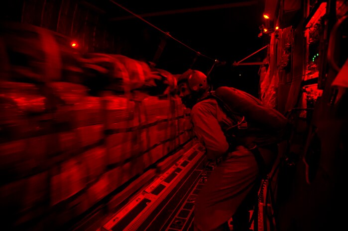 Staff Sgt. Stephen Adams, 816th Expeditionary Airlift Squadron loadmaster, releases 48,000 pounds of Meals, Ready to Eat out of a C-17 Globemaster III July 8, 2011 over Afghanistan during the concealment of the night sky. The crews also airdropped more than 73,000 pounds of JP8 fuel during their mission.  (U.S. Air Force photo by Staff Sgt. David Salanitri)