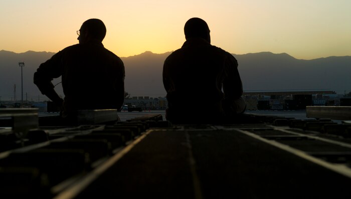 From left: Staff Sgts. Steven Holman and Stephen Adams, 816th Expeditionary Airlift Squadron loadmasters, take a moment to enjoy a sunset outside of their C-17 Globemaster III at Bagram Airfield, Afghanistan, July 8, 2011.  During the crew's 15-hour mission, they airdropped more than 73,000 pounds of JP8 fuel and 43,000 pounds of food. The sergeants are from Joint Base Charleston. (U.S. Air Force photo by Staff Sgt. David Salanitri)