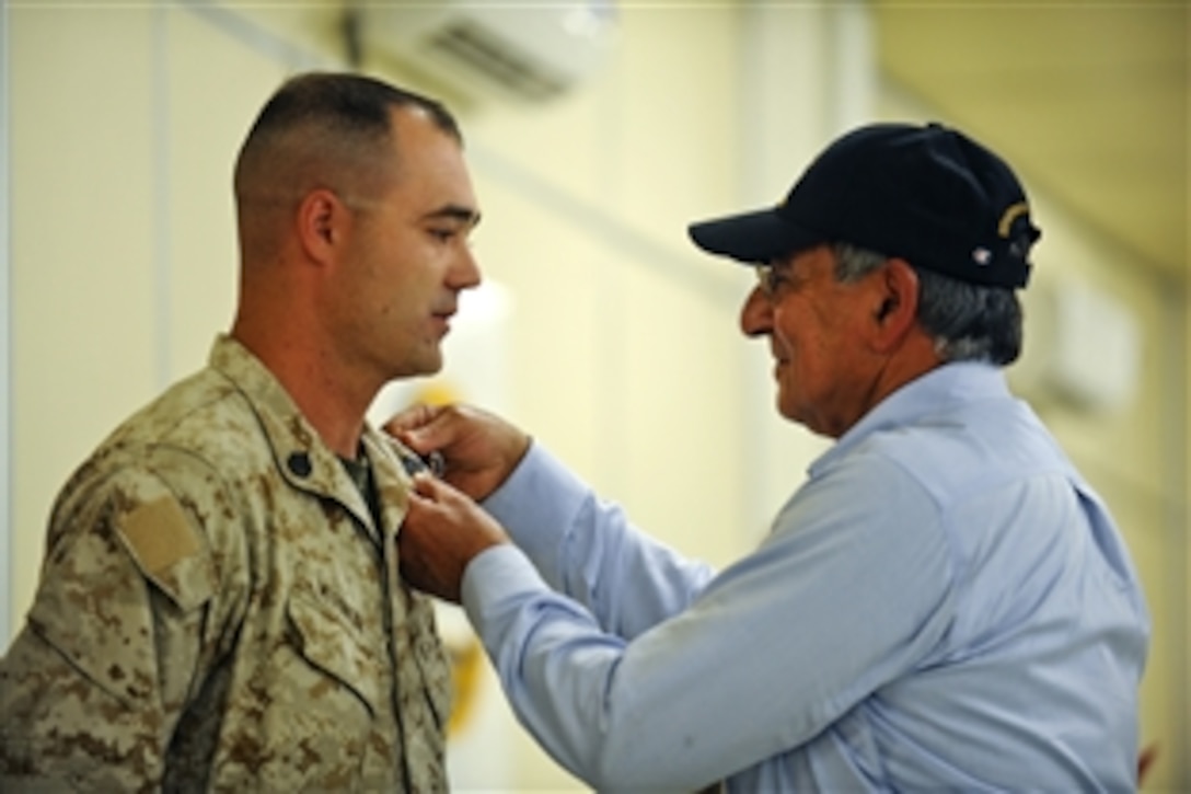 U.S. Defense Secretary Leon E. Panetta awards U.S. Marine Corps Shawn Vernon, Combat Logistics Battalion-7, the Purple Heart at Camp Dwyer, Afghanistan, July 10, 2011.