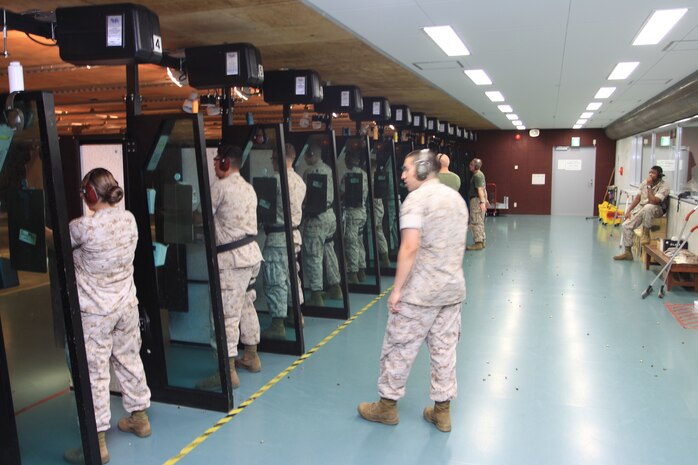 Sgt. Michael Lettko, combat marksmanship coach, gives advice while pacing between his shooters during a pistol detail at the Indoor Small Arms Range here Monday. Lettko encouraged his shooters to relax and stick to the fundamentals of shooting.