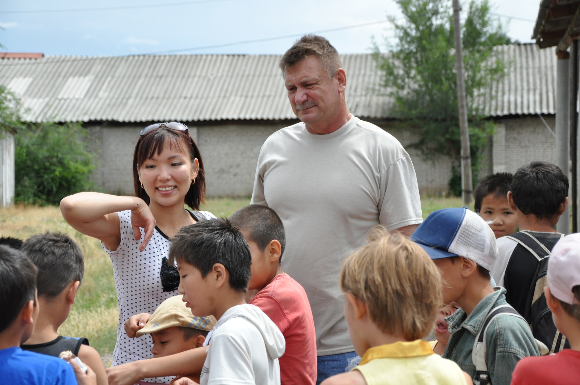 Begai (Becky) Tashtanalieva, 376th Security Forces Squadron translator, and Chief Master Sgt. Ronald Richardson, 376th SFS superintendent, talk with Kyrgyz children at the Red River Orphanage to see how they're doing. Richardson, deployed to the Transit Center at Manas in Kyrgyzstan from the 172nd Airlift Wing in Jackson, Miss., worked with Tashtanalieva to have his squadron's "Cops for Kids" support the orphanage. So far, the organization has paid for nine surgeries, and donated clothes and toys. (U.S. Air Force photo/Master Sgt. Cindy Dorfner)