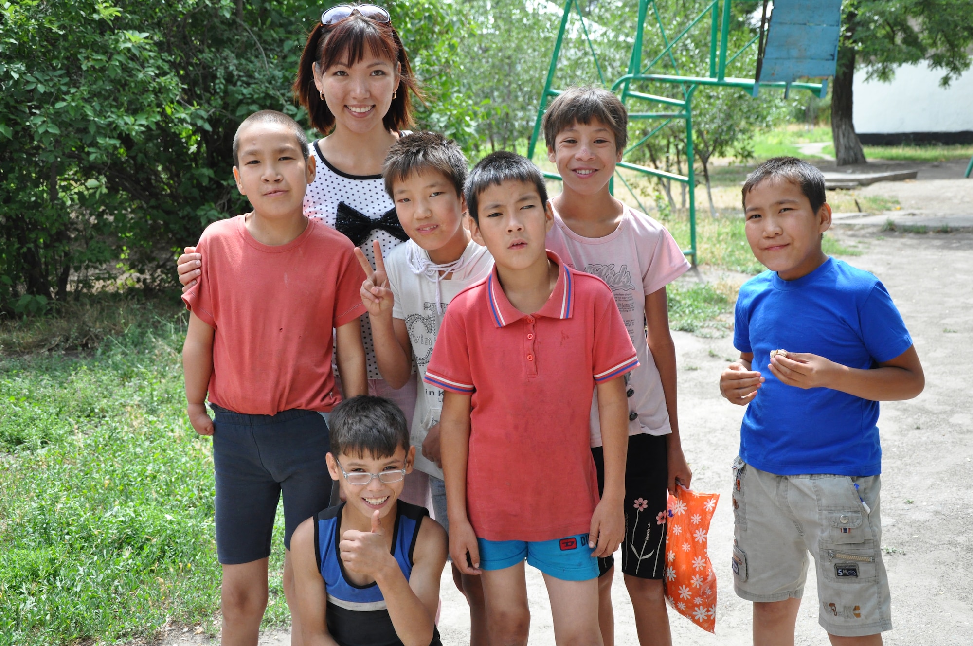 Begai (Becky) Tashtanalieva, 376th Security Forces Squadron translator, stands with six of the nine Red River Orphanage children who received surgeries paid for by the 376th SFS "Cops for Kids" organization. Five children underwent corrective eye surgery, three had cleft-lip operations and one had heart repair. (U.S. Air Force photo/Master Sgt. Cindy Dorfner)