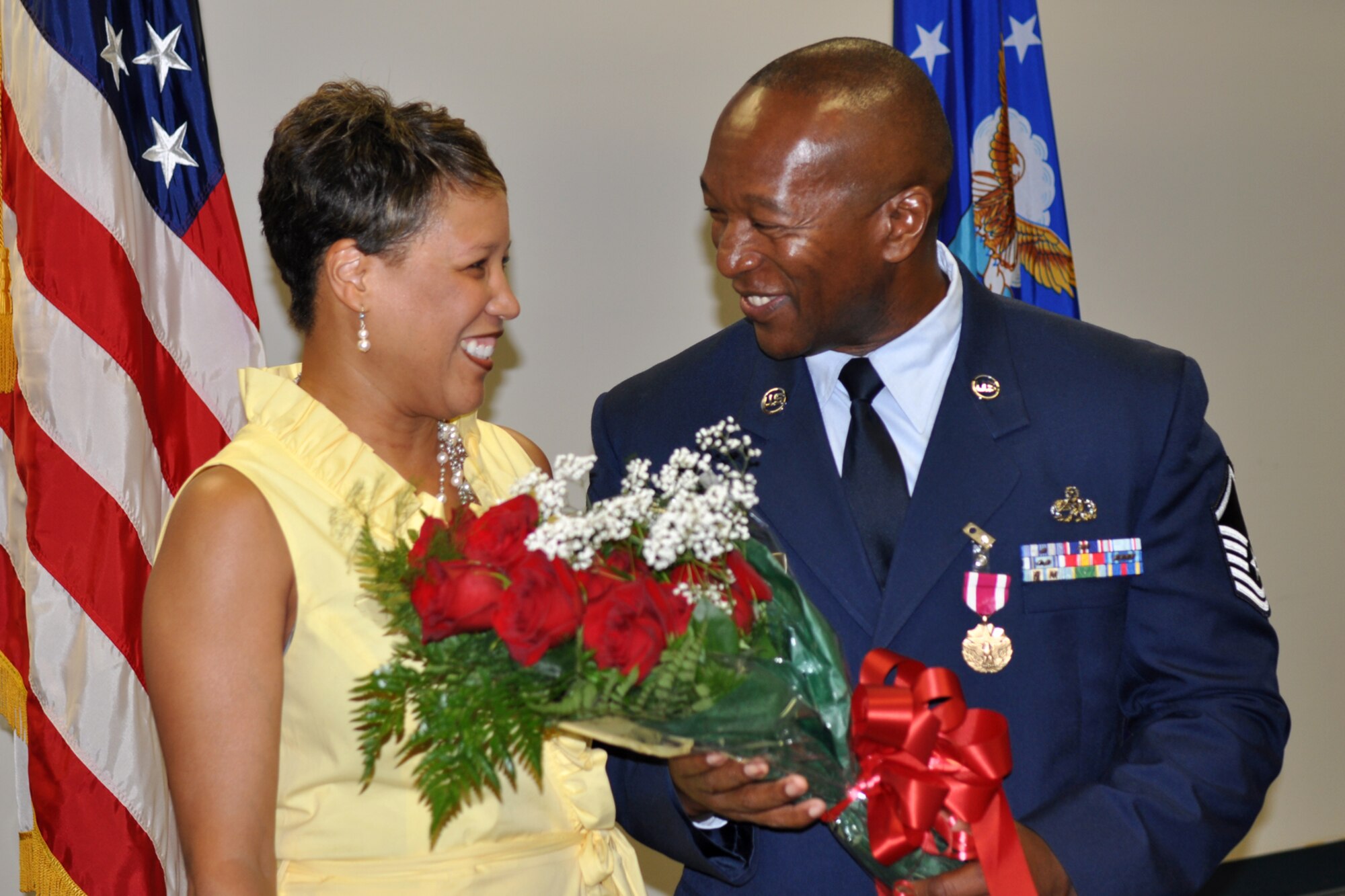 Master Sgt. Jonathon Gunn, electronics and environmental specialist with the 307th Bomb Wing, shares a light moment with his wife, Valerie, during his retirement ceremony at 307th Bomb Wing Headquarters building on Barksdale Air Force Base, La., July 9. The sergeant presented his wife a bouquet of roses as a show of appreciation for her support during his 33 years of military service. (U.S. Air Force photo/Staff Sgt. Ted Daigle) 