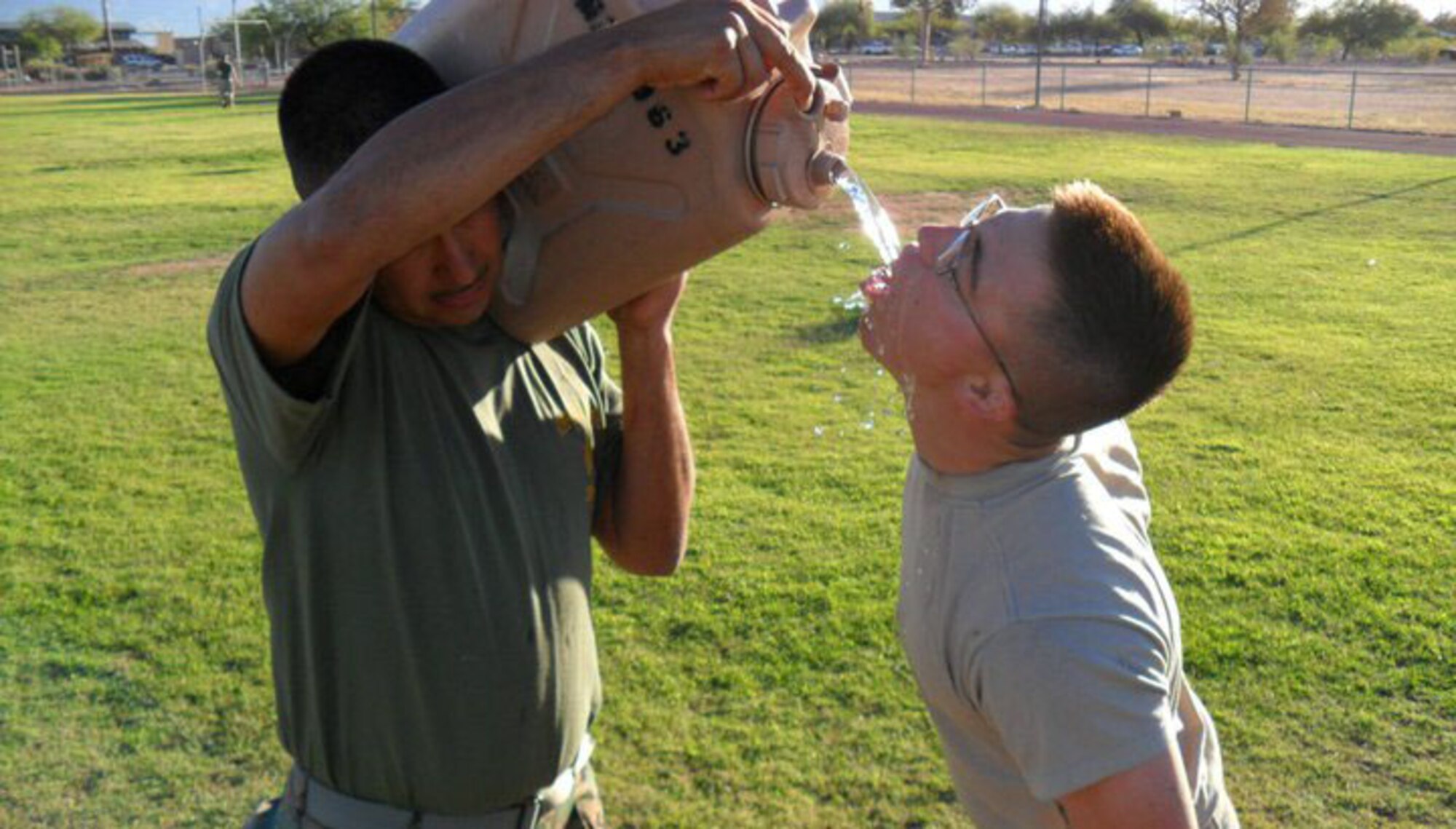 U.S. Air Force Senior Airman Ryan Vottero takes time to hydrate with the help of instructor U.S. Marine Corps Staff Sgt. Robert Sena during a training session of the Corporals Course held at Davis-Monthan Air Force Base, Ariz. June 10-14. Six Airmen recently attended the Marine Corps’ Corporals Course, a program which trains corporals for their transition to the rank of noncommissioned officer. (Courtesy photo)