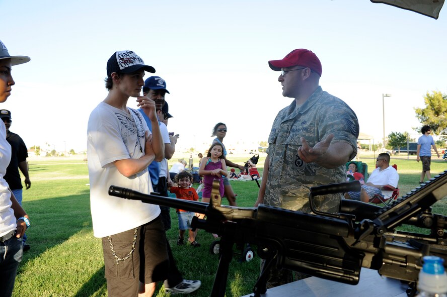 Tech. Sgt. Aric Jacobsen, noncommisioned officer in charge of the 56th Security Forces Squadron combat arms training and maintenance flight, explains the properties of the weapons displayed during Freedom Fest at Luke Air Force Base, Ariz., July 4, 2011. (U.S Air Force photo by Staff Sgt. Jason Colbert)