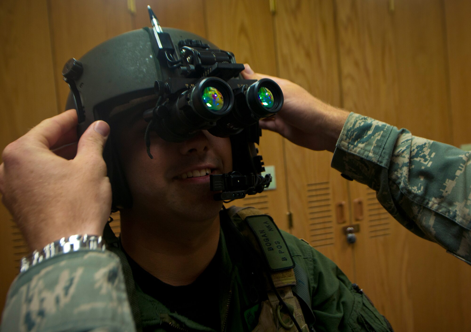 U.S. Air Force Staff Sgt. Antonio Delvercchio, 41st Rescue Squadron flight engineer, has a pair of night vision goggles fitted to his helmet by an aircrew flight equipment member while demonstrating the proper equipment needed before taking off on a night flight at Moody Air Force Base, Ga., July 11, 2011. Every piece of equipment that’s worn during the flight has to be inspected by the AFE member, making their job highly important. (U.S. Air Force photo by Airman 1st Class Joshua Green/Released)
