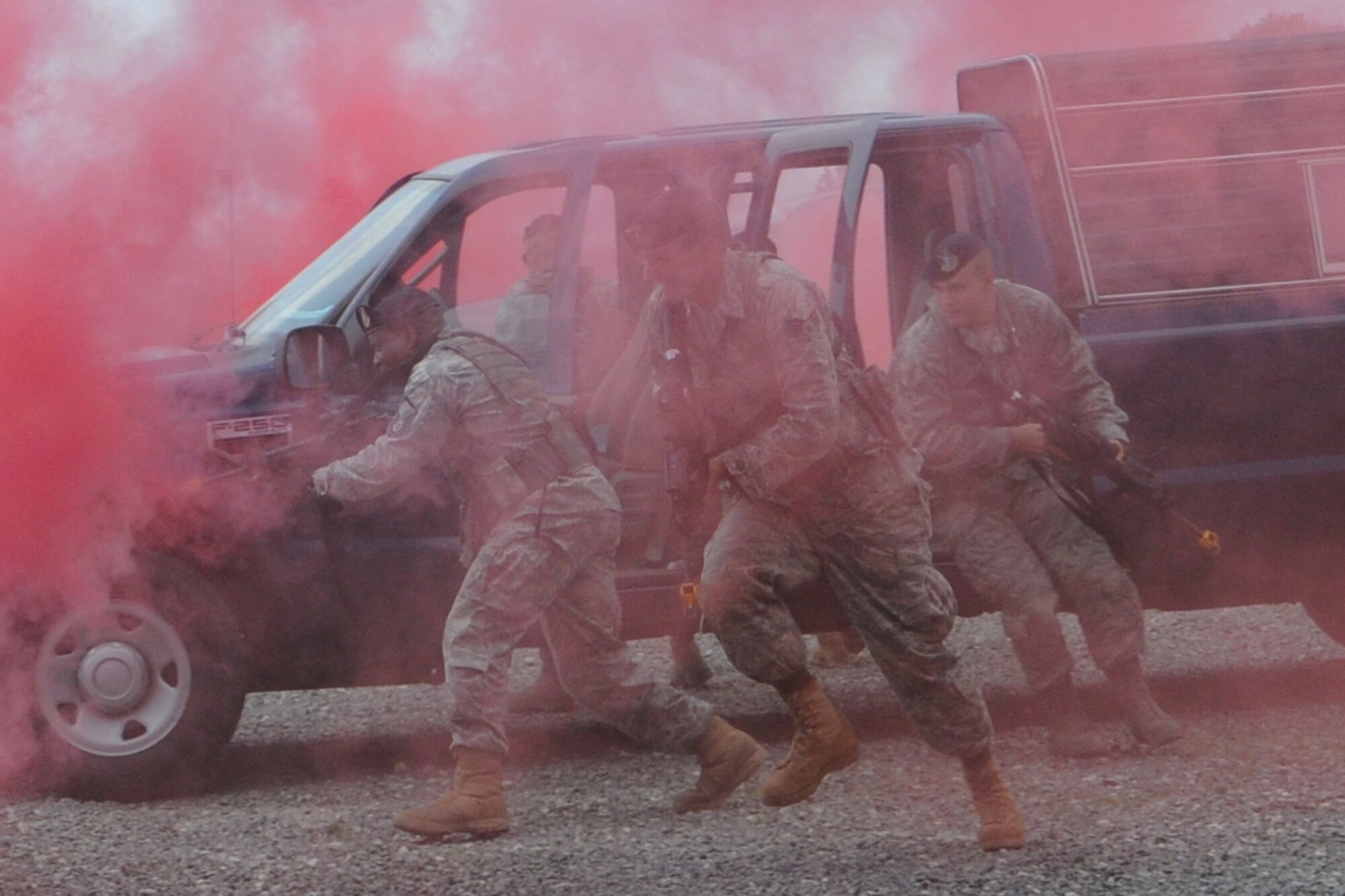 YOUNGSTOWN AIR RESERVE STATION, Ohio -- Members of the 910th Security Forces Squadron rush from a response vehicle amid smoke billowing from canisters during a scenario as part of the Air Force Reserve's 910th Airlift Wing's annual Employer Awareness Day here, July 10, 2011. The goal of the event is to increase the awareness of civilian employers to importance of the role Air Force Reservists have in the U.S. military. U.S. Air Force photo by Tech. Sgt. Rick Lisum
