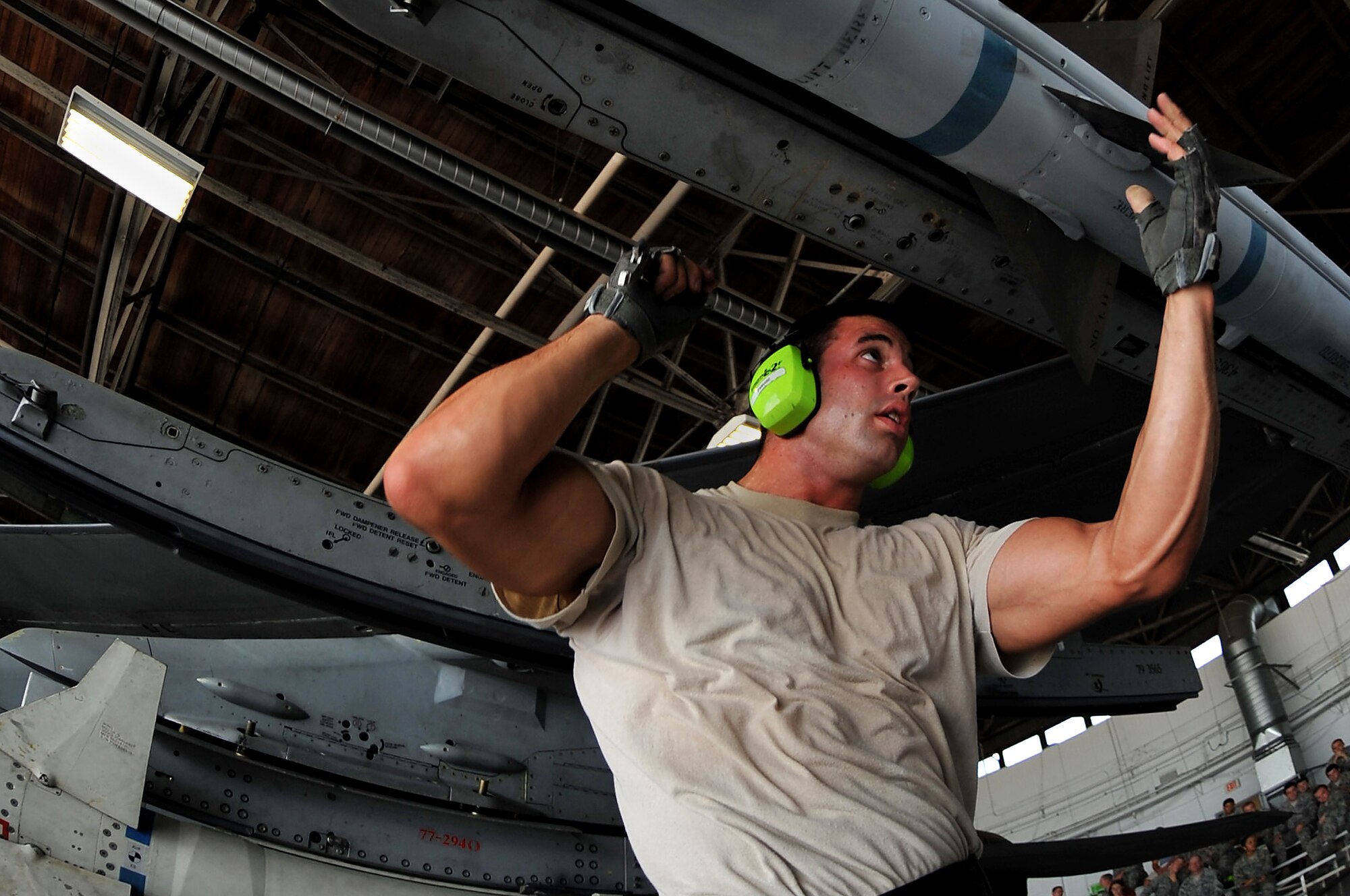 SHAW AIR FORCE BASE, S.C. -- A 79th Aircraft Maintenance Unit weapons load member, rushes to complete a few finishing touches while mounting an air intercept missile (AIM-120) during a weapons load competition here July 8, 2011. The 20th Fighter Wing weapons standardization held their quarterly weapons load crew of the quarter competition. The competition brings together weapons load crew members from all three fighter squadrons at Shaw to compete against each other to show who is the best. (U.S. Air Force photo by Senior Airman Kenny Holston)(Released)

