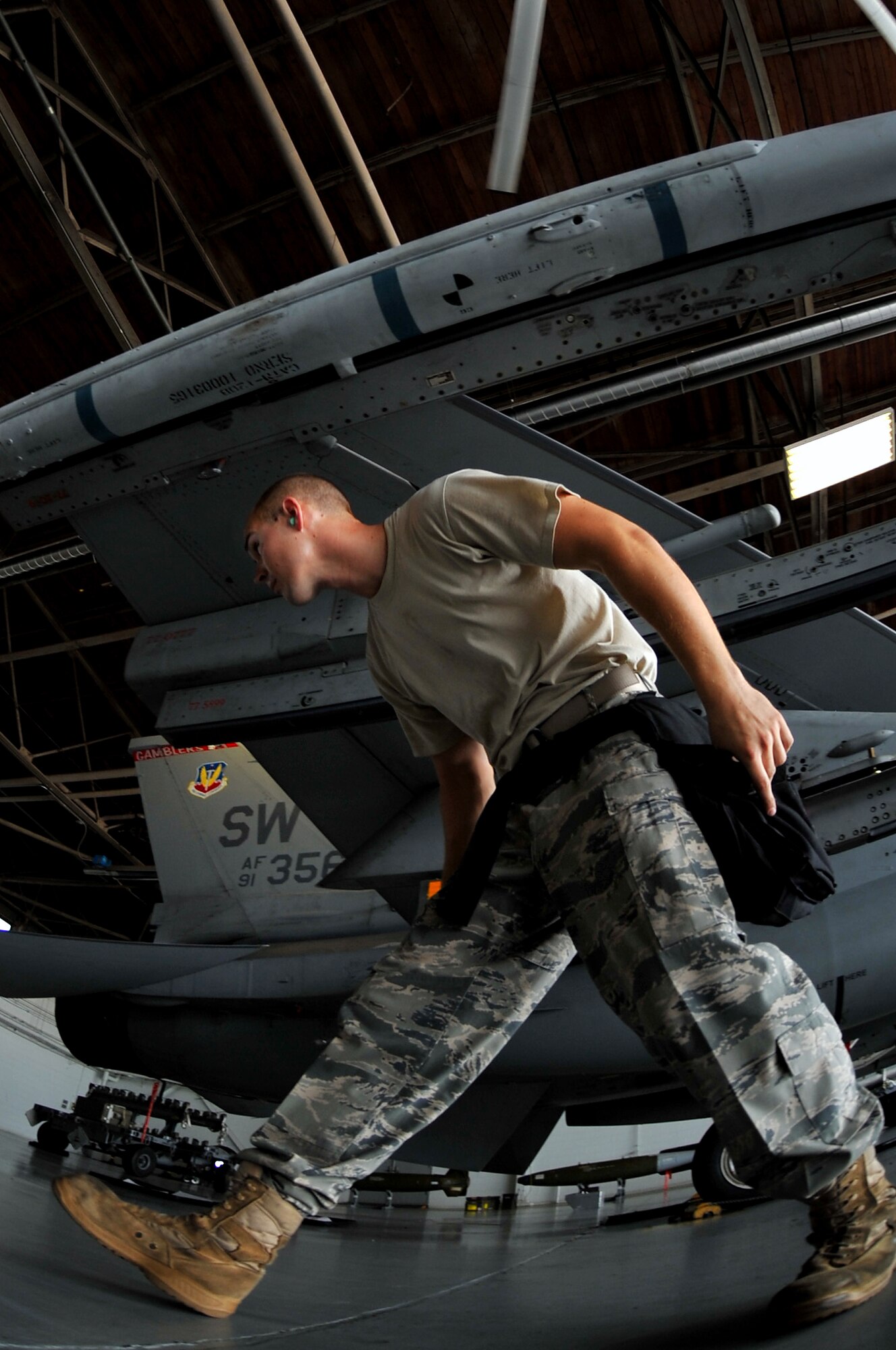 SHAW AIR FORCE BASE, S.C. -- A 77th Aircraft Maintenance Unit weapons load member, quickly makes his way around the wing of an F-16 to continue helping his team load munitions onto the aircraft during a weapons load competition here July 8, 2011. The 20th Fighter Wing weapons standardization held their quarterly weapons load crew of the quarter competition. The competition brings together weapons load crew members from all three fighter squadrons at Shaw to compete against each other to show who is the best. (U.S. Air Force photo by Senior Airman Kenny Holston)(Released)

