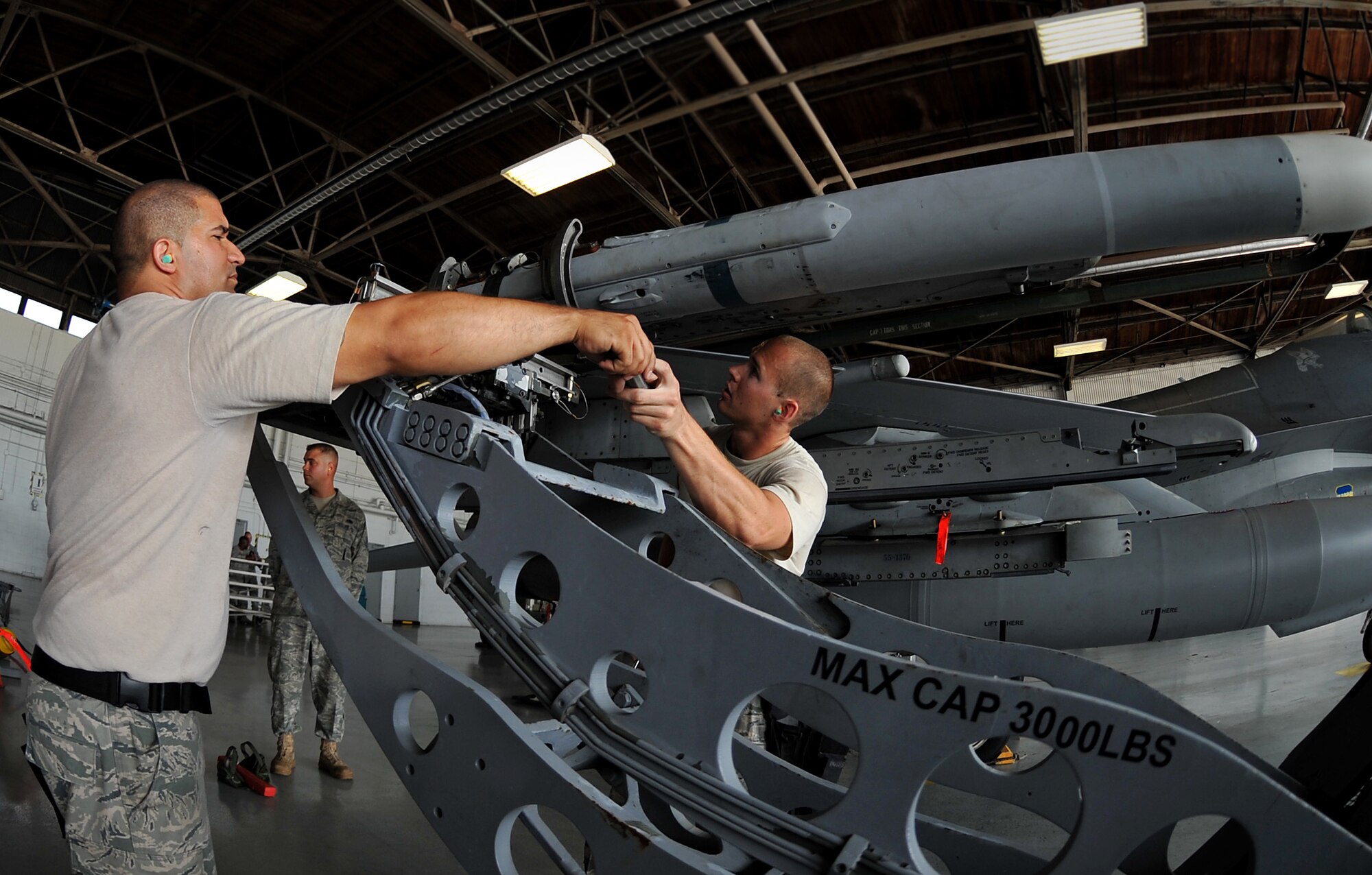 SHAW AIR FORCE BASE, S.C. -- Weapons load members with the 77th Aircraft Maintenance Unit, hand off tools as they work together to mount an air intercept missile (AIM-120) during a weapons load competition here July 8, 2011. The 20th Fighter Wing weapons standardization held their quarterly weapons load crew of the quarter competition. The competition brings together weapons load crew members from all three fighter squadrons at Shaw to compete against each other to show who is the best. (U.S. Air Force photo by Senior Airman Kenny Holston)(Released)

