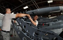 SHAW AIR FORCE BASE, S.C. -- Weapons load members with the 77th Aircraft Maintenance Unit, hand off tools as they work together to mount an air intercept missile (AIM-120) during a weapons load competition here July 8, 2011. The 20th Fighter Wing weapons standardization held their quarterly weapons load crew of the quarter competition. The competition brings together weapons load crew members from all three fighter squadrons at Shaw to compete against each other to show who is the best. (U.S. Air Force photo by Senior Airman Kenny Holston)(Released)

