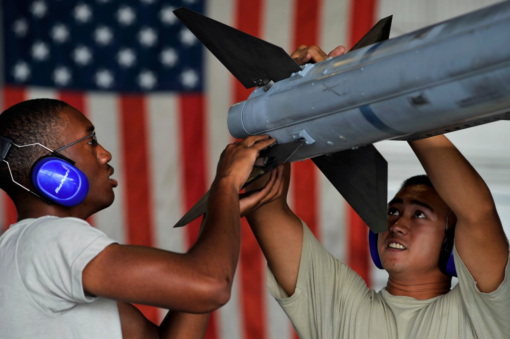 SHAW AIR FORCE BASE, S.C. - Airman 1st Class Joseph Myers (left), and Senior Airman Gerry Escalona, 55th Aircraft Maintenance Unit weapons load members, work together to quickly mount munitions onto an F-16 during a weapons load competition here July 8, 2011. The 20th Fighter Wing weapons standardization held their quarterly weapons load crew of the quarter competition. The competition brings together weapons load crew members from all three fighter squadrons at Shaw to compete against each other to show who is the best. (U.S. Air Force photo by Senior Airman Kenny Holston)(Released) 

