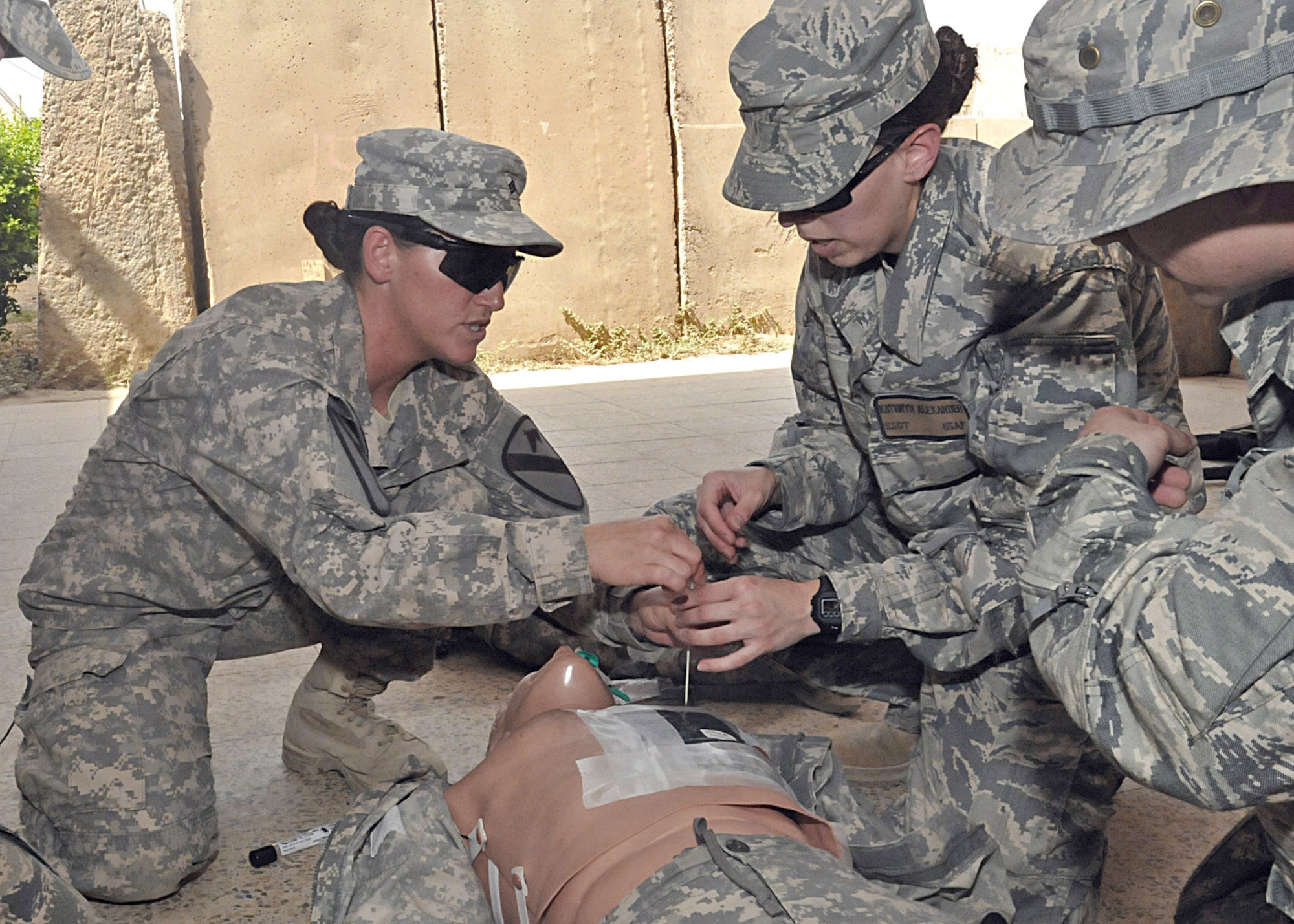Using a medical mannequin, Army Sgt. Brenda Goode (left) shows Staff Sgt. Kathryn Alexander how to treat a chest wound during a tactical field care exercise, July 7, 2011, at Contingency Operating Site Marez, Iraq.  Goode, who served as one of the primary instructors for the five-day combat lifesaver course, is a combat medic assigned to Company C, 27th Brigade Support Battalion at COS Marez.  Alexander is a financial management specialist assigned to the Air Force Financial Management Detachment there. (U.S. Army photo/Spc. Terence Ewings)