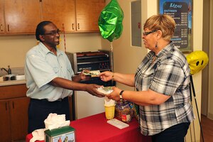 Jock McCarthy, Eaglewood Golf Course Putter Shack employee, hands a hot dog to Lila Whitlow, 633rd Force Support Squadron custodial worker, at Langley Air Force Base, Va., July 11, 2011. The Putter Shack is open Mondays through Fridays from 6 to 9 a.m. and then from 10 a.m. to 1 p.m. (U.S. Air Force photo by Airman 1st Class Kayla Newman/Released)