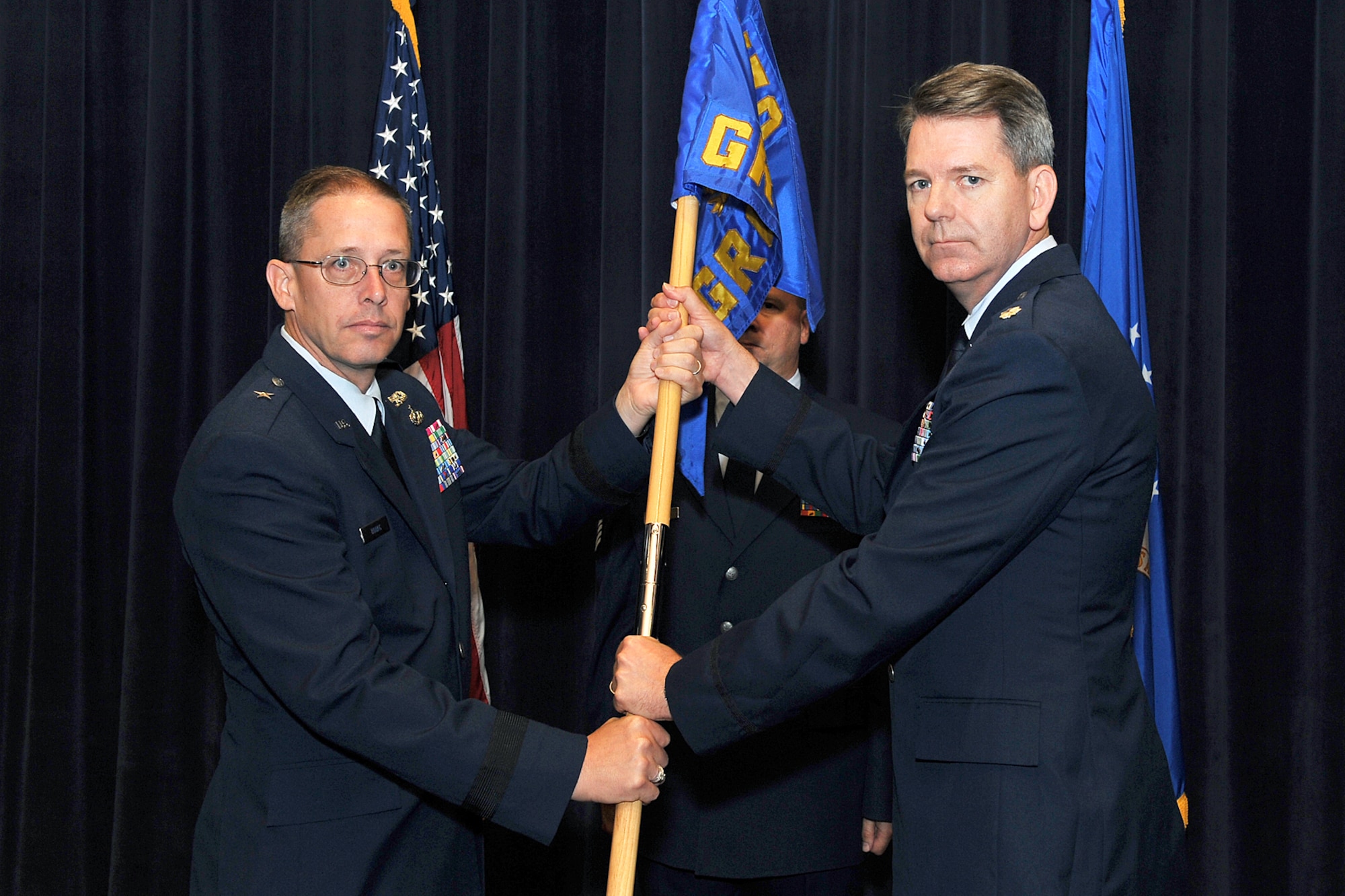 U.S. Air Force Brig. Gen. Daryl Bohac, assistant adjutant general, Nebraska Air National Guard, passes the guidon to Lt. Col. James Stevenson, incoming 170th Group commander, during a change of command ceremony inside the Air Force Weather Agency's auditorium on Offutt Air Force Base, Neb., July 9. (U.S. Air Force Photo by Charles Haymond/Released)
