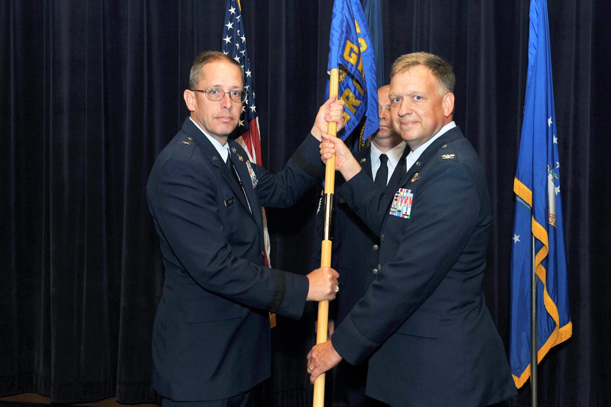 U.S. Air Force Col. Mark White, 170th Group commander, relinquishes command and passes the guidon to Brig. Gen. Daryl Bohac, assistant adjutant general, Nebraska Air National Guard, during a change of command ceremony inside the Air Force Weather Agency's auditorium on Offutt Air Force Base, Neb., July 9. (U.S. Air Force Photo by Charles Haymond/Released)
