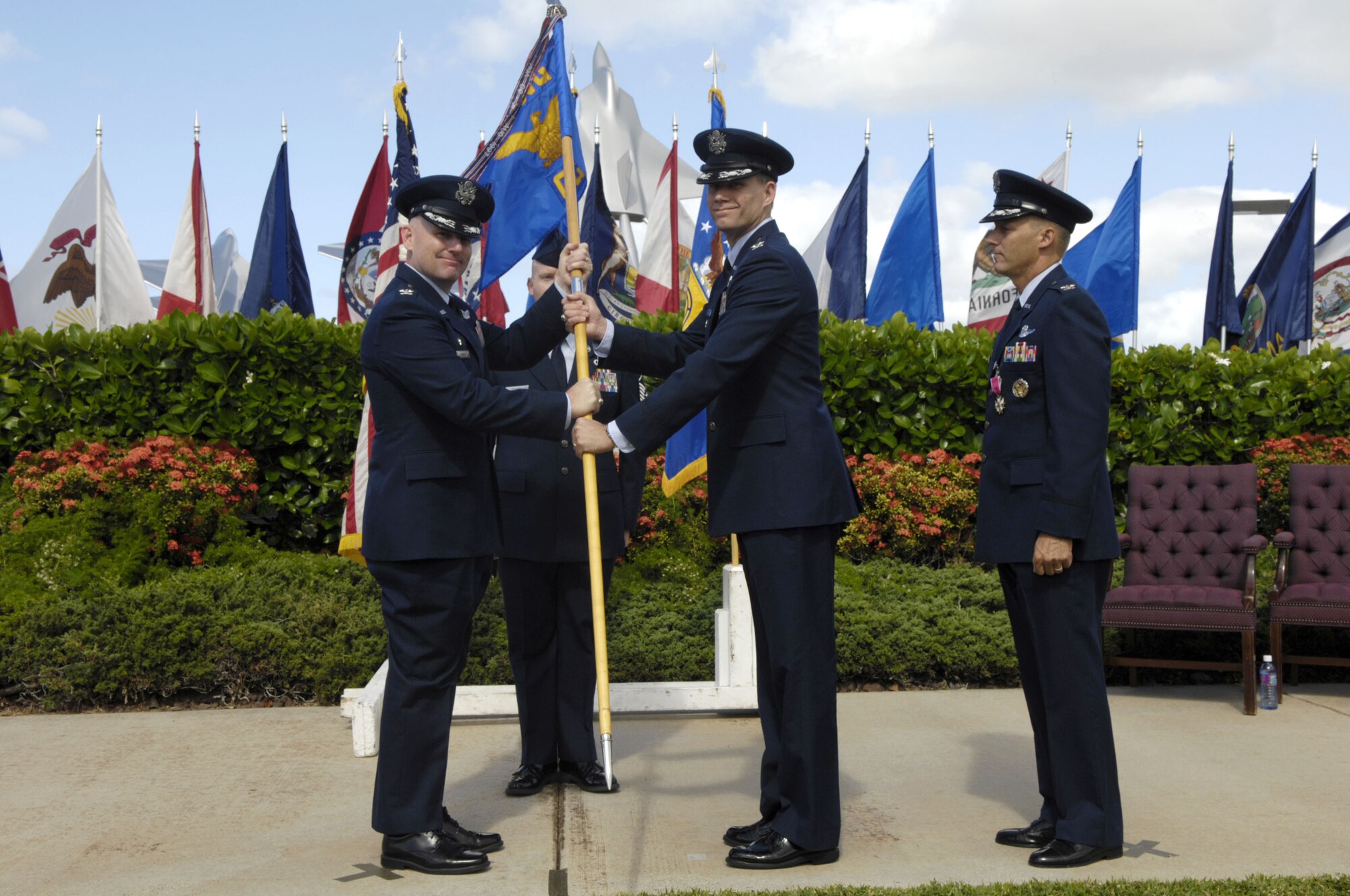 Col. Sam Barrett, 15th Wing commander, passes the guidon to Col. David Baldessari, 15th Operations Group commander, during a change of command ceremony here, July 8. Colonel Jeffrey Morgan, outgoing 15 OG CC, is making a permanent change of station to the Pentagon and relinquished command to Colonel Baldessari. Colonel Baldessari, a U.S. Air Force Academy graduate, entered the Air Force in 1989. He is a command pilot with more than 3,700 flight hours. He previously served as the United States Transportation Command Liaison Officer to North American Aero Space Defense. (U.S. Air Force photo/Dave Underwood)