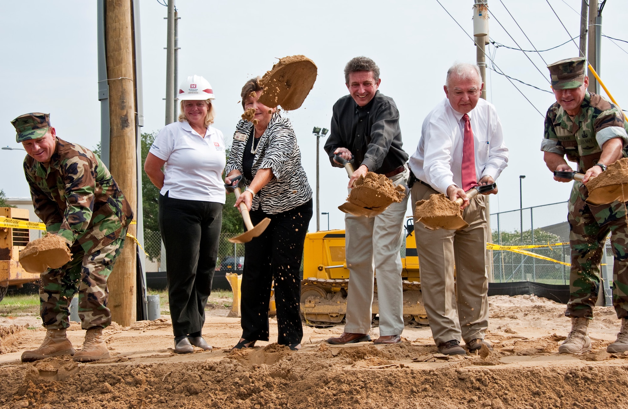 Leaders from the Naval Explosive Ordnance Disposal School and others officially break ground during a ceremony July 8 at Eglin Air Force Base, Fla.  The location will be the site of new EOD student dorms.  The truly "purple" project is Navy funded, managed by the Army Corps of Engineers and located on an Air Force base and will be home to students from all four branches of the military.  Col. Sal Nodjomian, the 96th Air Base Wing commander, said he was excited for the future EOD students, who will experience outstanding living conditions and quality of life improvements.  He applauded the planners and designers of the project, as the new facility will be constructed to stringent energy-saving criteria.  (U.S. Air Force photo/Sachel Seabrook)