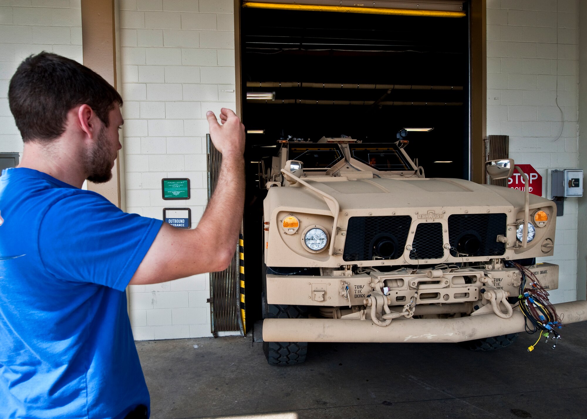 Joey Shortt-Tabor of 96th Logistics Readiness Squadron cargo movement, directs an Air Force Mine Resistant Ambush Protected vehicle out of the warehouse to be loaded on a tractor trailer.  The 45 people in LRS' cargo movement unload and ship out an almost 15,000 pieces through commercial carriers each year.  Their in-house capabilities allow them to create virtually any type of shipping material needed to store, secure and ship an item from Eglin.  (U.S. Air Force photo/Samuel King Jr.)   
