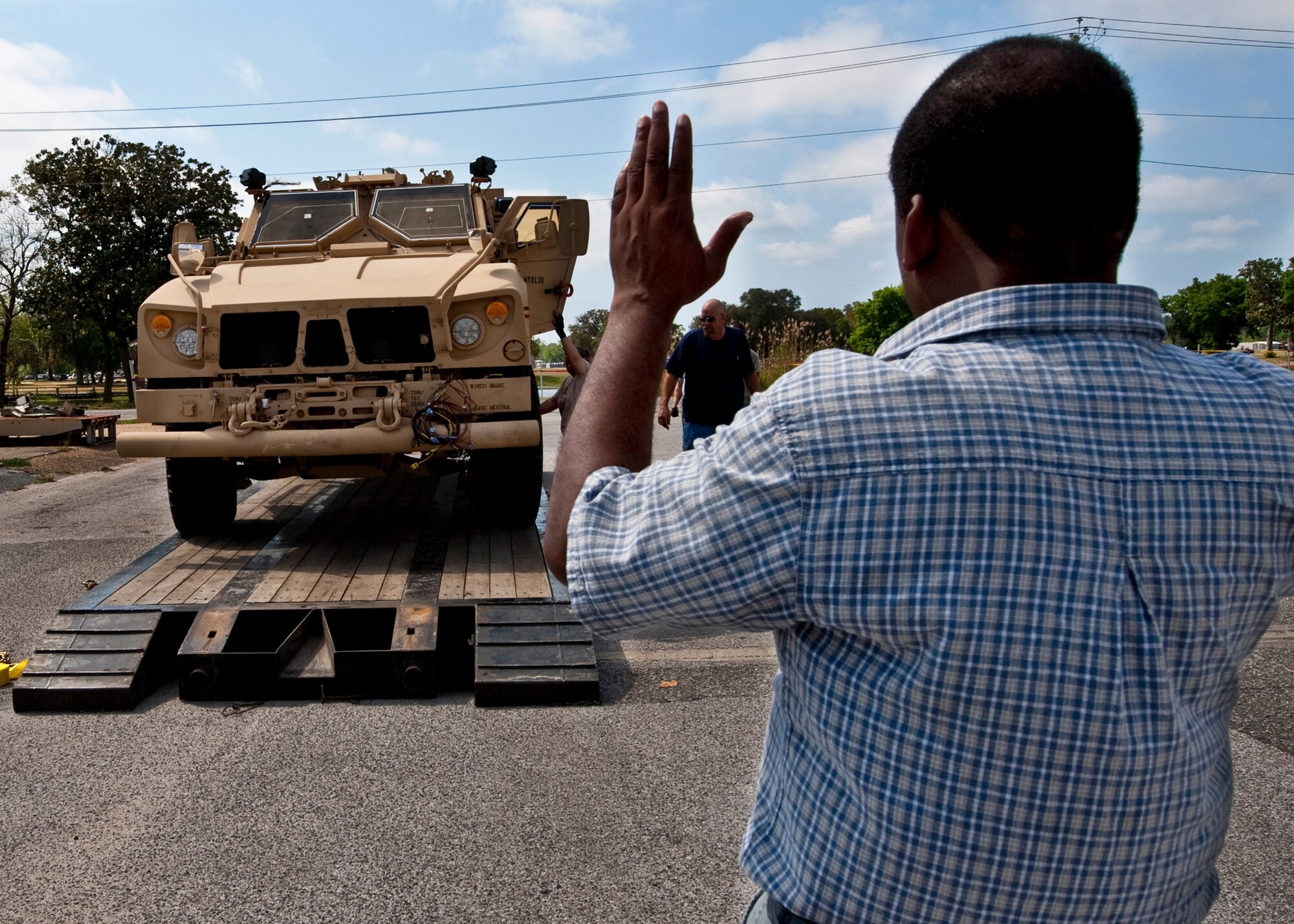 Angus Friend of 96th Logistics Readiness Squadron cargo movement, helps the driver of an Air Force Mine Resistant Ambush Protected vehicle find the center of the trailer before the vehicle is shipped out.  The 45 people in LRS' cargo movement unload and ship out an almost 15,000 pieces through commercial carriers each year.  Their in-house capabilities allow them to create virtually any type of shipping material needed to store, secure and ship an item from Eglin.  (U.S. Air Force photo/Samuel King Jr.)   