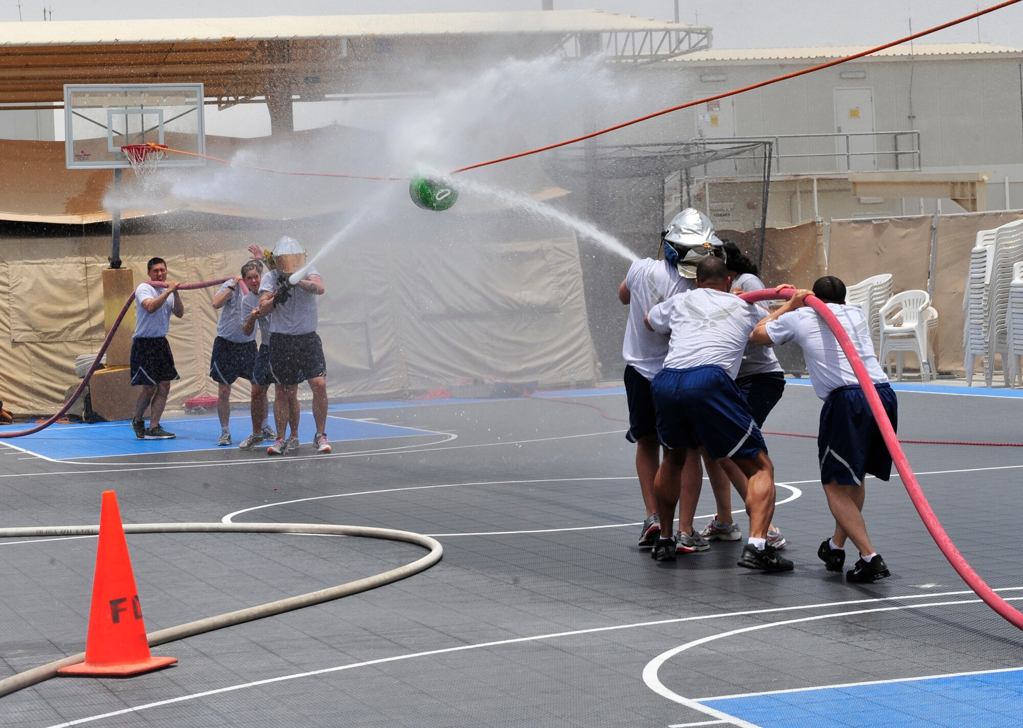 Airmen from the 380th Civil Engineer Squadron Emergency Management section compete against Airmen from the 380th Expeditionary Medical Group during a fire muster competition July 10, 2011. Six teams competed in the event, which was organized by the fire department and has become a tradition during each deployment rotation at the 380th Air Expeditionary Wing. The team from the Expeditionary Logistics Readiness Squadron won the event. (U.S. Air Force photo by Staff Sgt. Patrick Mitchell)
