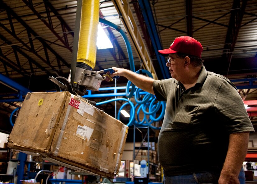 Art Ellington of 96th Logistics Readiness Squadron cargo movement, moves a heavy box via a vacuum lift system at Eglin Air Force Base, Fla.  The cargo movement section has the ability to create almost any type of shipping crate, box or packing material needed to secure a package and ship it out.  (U.S. Air Force photo/Samuel King Jr.)   