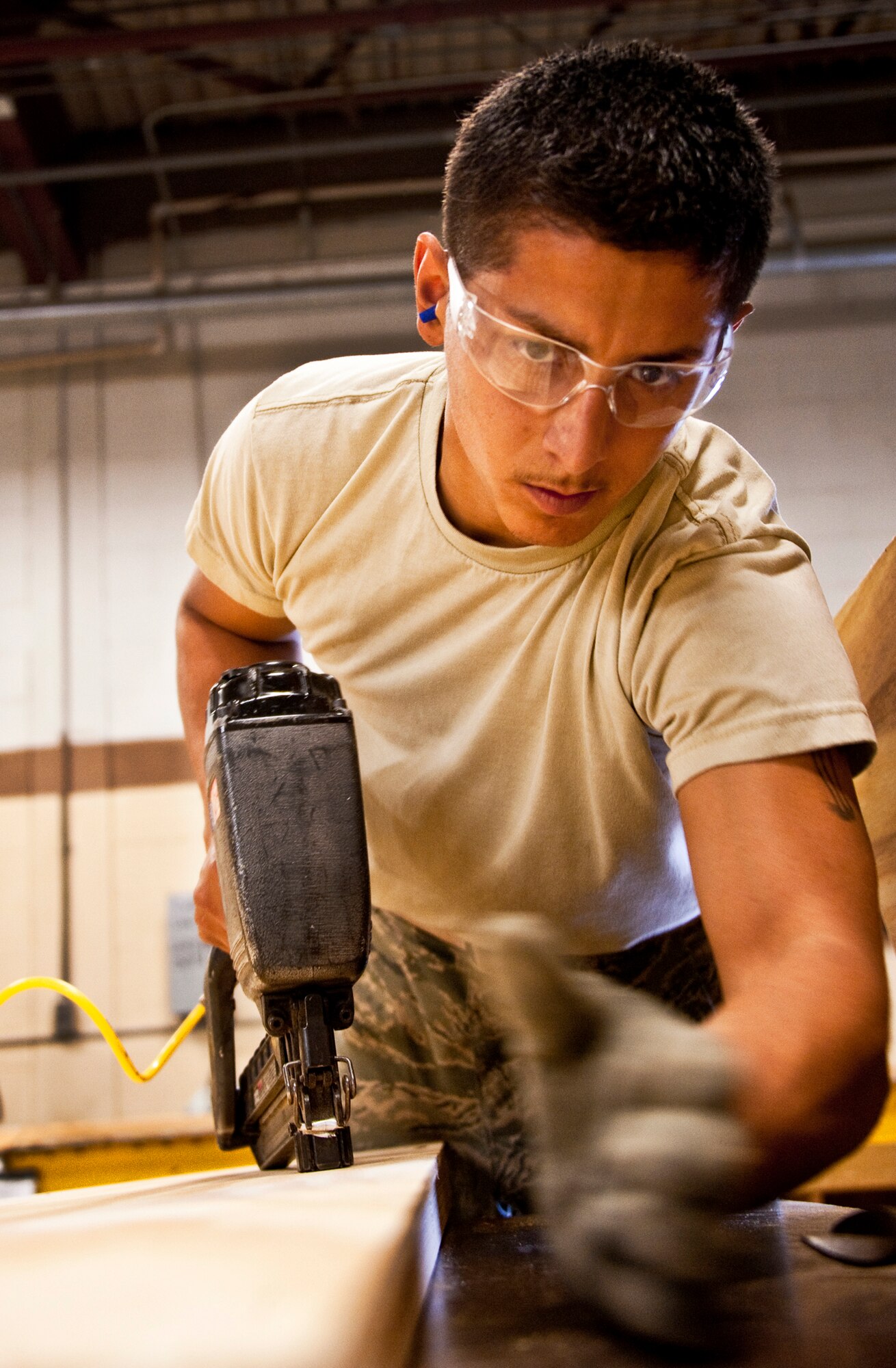 Airman 1st Class Jeremy Gonzales of 96th Logistics Readiness Squadron cargo movement, ensures the board is straight and in place before nailing the board into place with a nail gun.  The wood will be used to create a box to secure and ship a large item from the base.  Measurements of the items to be shipped are taken and used to produce specifications for the type of box needed to ship it.  Personnel in the wood shop can build a box to meet those specifications needed to secure and ship the item.  (U.S. Air Force photo/Samuel King Jr.)   