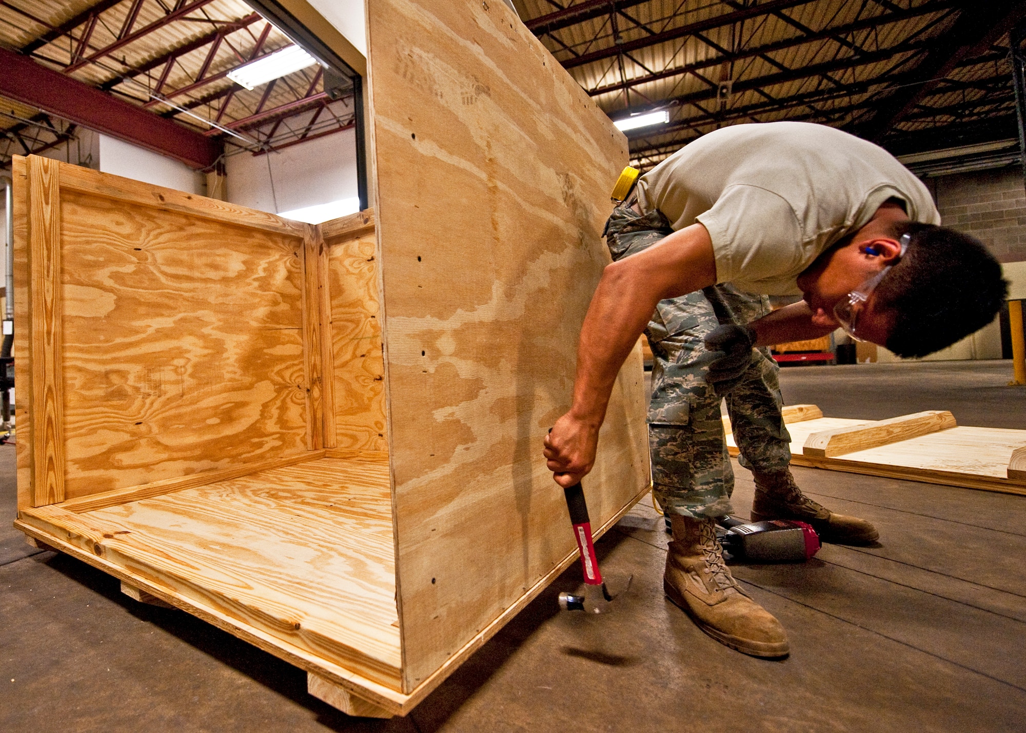 Airman 1st Class Jeremy Gonzales of 96th Logistics Readiness Squadron cargo movement, completes the third side of the wooden box he built for shipping an item from Eglin Air Force Base, Fla.  Measurements of the items to be shipped are taken and used to produce specifications for the type of box needed to ship it.  Personnel in the wood shop can build a box to meet those specifications needed to secure and ship the item.  (U.S. Air Force photo/Samuel King Jr.)   