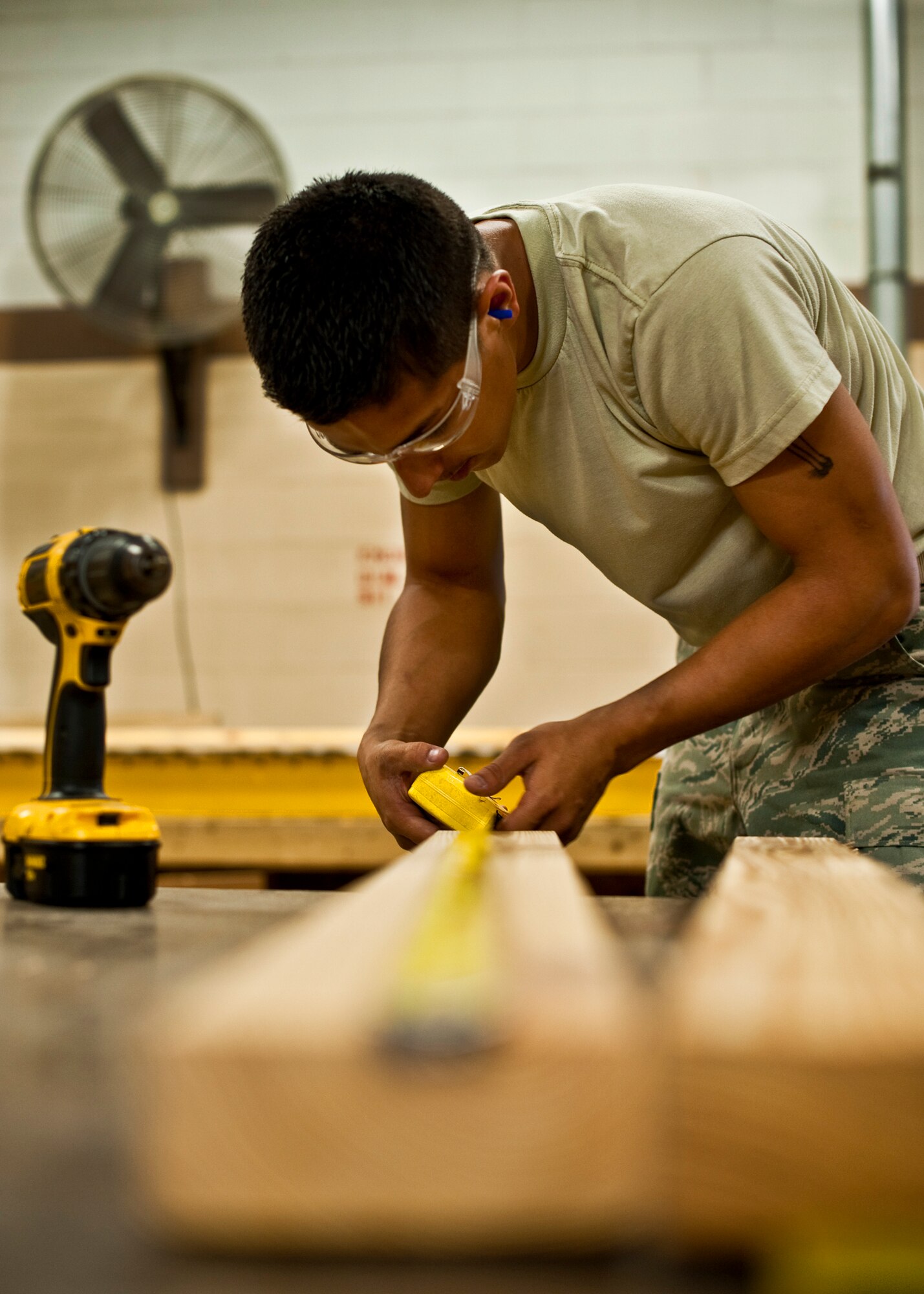 Airman 1st Class Jeremy Gonzales of 96th Logistics Readiness Squadron cargo movement, measures a 2x4 prior to nailing it into place on a wooden box.  The box will be used to secure and ship a large item from the base.  Measurements of the items to be shipped are taken and used to produce specifications for the type of box needed to ship it.  Personnel in the wood shop can build a box to meet those specifications needed to secure and ship the item.  (U.S. Air Force photo/Samuel King Jr.)   