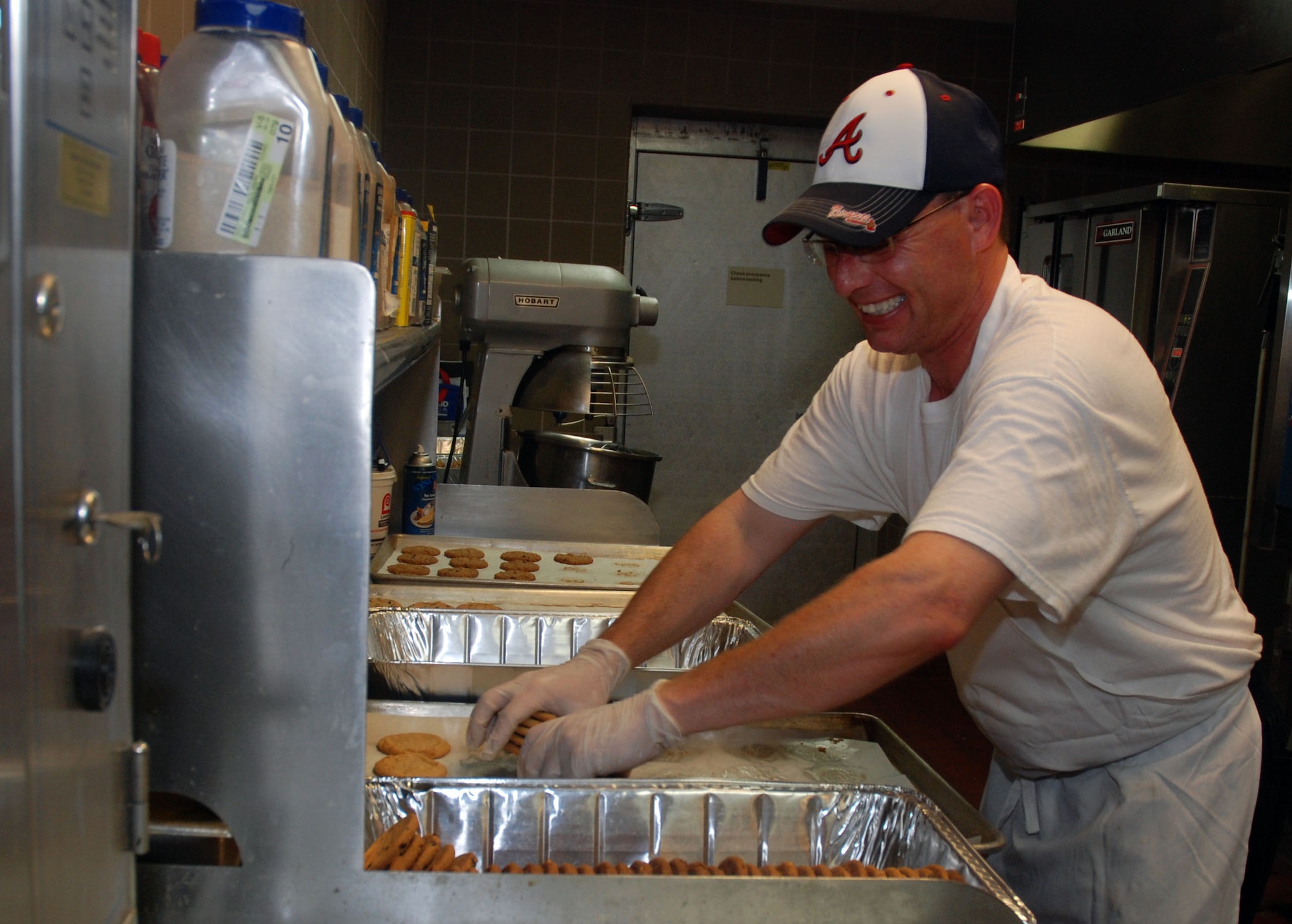 Mike Medford, Dobbins Air Reserve Base chef, is finishing up a batch of cookies at the Consolidated Club during the July unit training assembly.  Medford has had a history of success in the academia of culinary arts from his formal inauguration into the field in 2008, graduating magna cum laude from Le Cordon Blue in Tucker, Ga. to his more recent graduation, number three in his class, from the Culinary Institute of America’s satellite location in San Antonio, Texas. (U.S. Air Force photo/ Senior Airman Danielle Campbell)