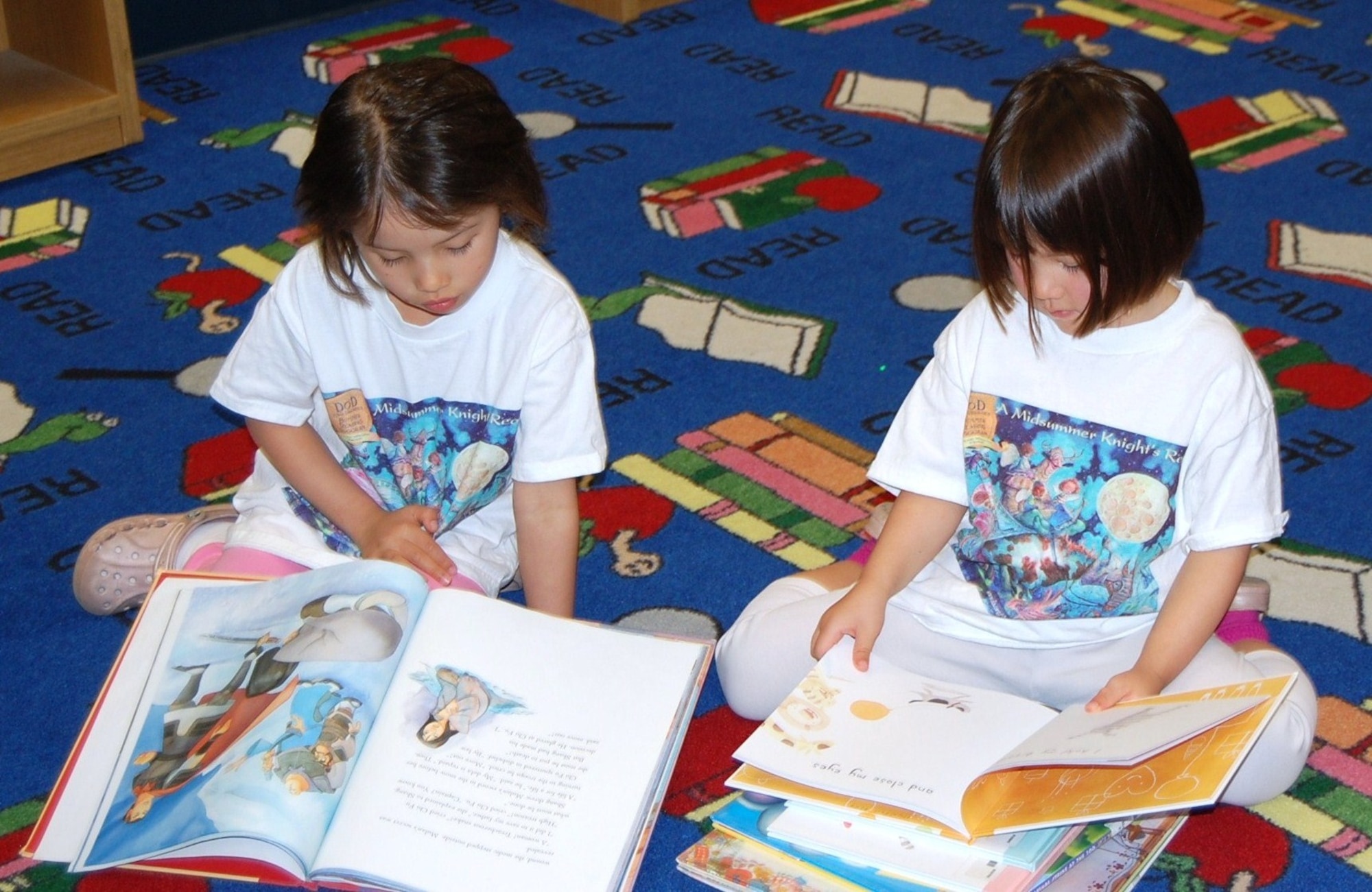 LAUGHLIN AIR FORCE BASE, Texas-- Two Laughlin children read their selected books during Laughlin’s Book Mark Library’s ‘A Midsummer Knight’s Read’ program July 5. The program challenges students to read 12 age-appropriate books or read for more than 12 hours. (U.S. Air Force photo by Gaby Jimenez)