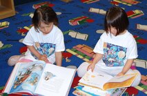 LAUGHLIN AIR FORCE BASE, Texas-- Two Laughlin children read their selected books during Laughlin’s Book Mark Library’s ‘A Midsummer Knight’s Read’ program July 5. The program challenges students to read 12 age-appropriate books or read for more than 12 hours. (U.S. Air Force photo by Gaby Jimenez)