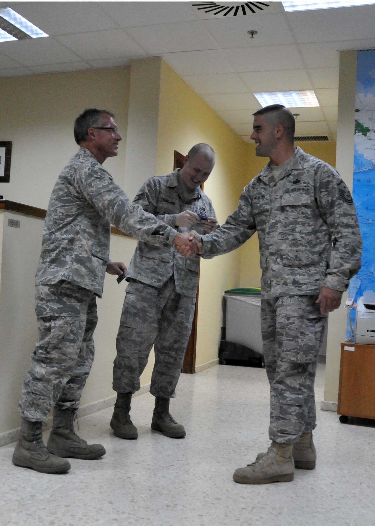 Master Sgt. Mike A. Schmaling, First Sergeant, 313th Air Expeditionary Wing, distributes telephone cards supplied by the Unformed Service Organization to Lt. Col. Kevin R. Shomin (left) and Staff. Sgt. Cody Sturgeon (middle) on July 11, 2011 at a base in Western Europe. (U.S. Air Force photo/Capt. John P. Capra)