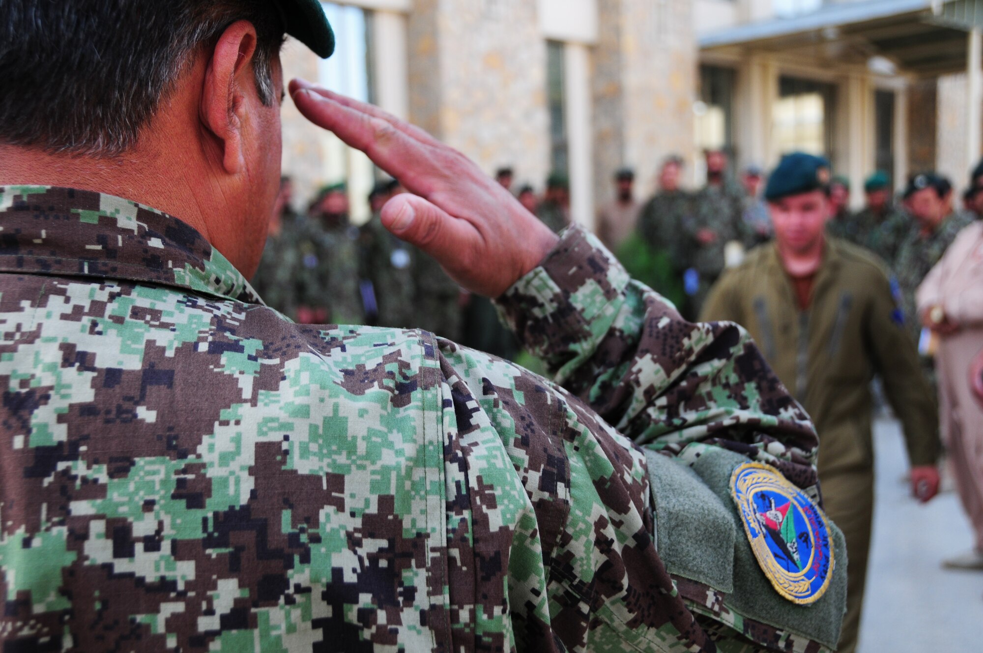 An Afghan Air Force maintenance commander salutes an AAF member at a graduation ceremony marking the occasion of the first-ever rotary-wing maintenance train-the-trainer course at Kabul International Airport, Kabul, Afghanistan July 11, 2011.  The graduating group is now qualified to instruct three different training levels outlined in their training records.  Master Sgt. Walt Shaffer, deployed from Kirtland AFB, N.M., facilitated the training.  (U.S. Air Force photo by Senior Airman Amber Williams)