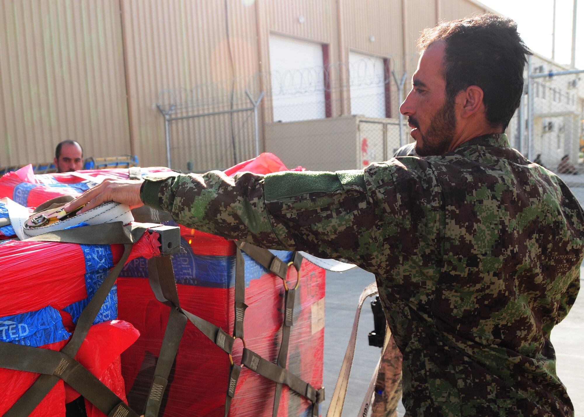 An Afghan Air Force Airman prepares cargo netting for a recent shipment of AAF helicopter parts at Kabul International Airport, Kabul, Afghanistan, June 6, 2011. Deployed Airmen here at the 438th Air Expeditionary Wing, are responsible for setting the conditions for a professional, fully independent and operationally-capable Afghan Air Force. (U.S. Air Force photo by Senior Airman Amber Williams)