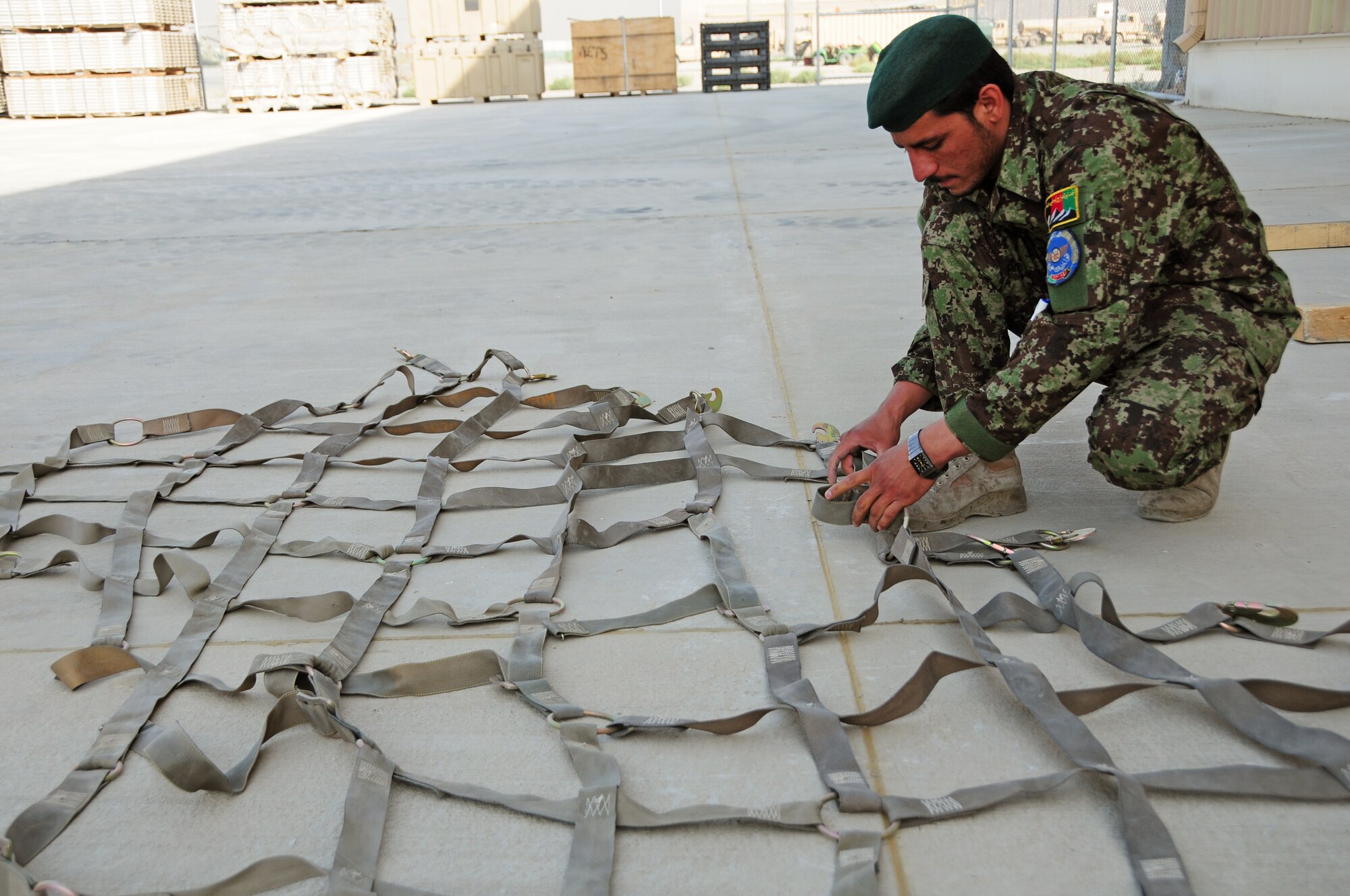 An Afghan Air Force Airman prepares cargo netting for a recent shipment of AAF helicopter parts at Kabul International Airport, Kabul, Afghanistan, June 6, 2011. Deployed Airmen here at the 438th Air Expeditionary Wing, are responsible for setting the conditions for a professional, fully independent and operationally-capable Afghan Air Force. (U.S. Air Force photo by Senior Airman Amber Williams)