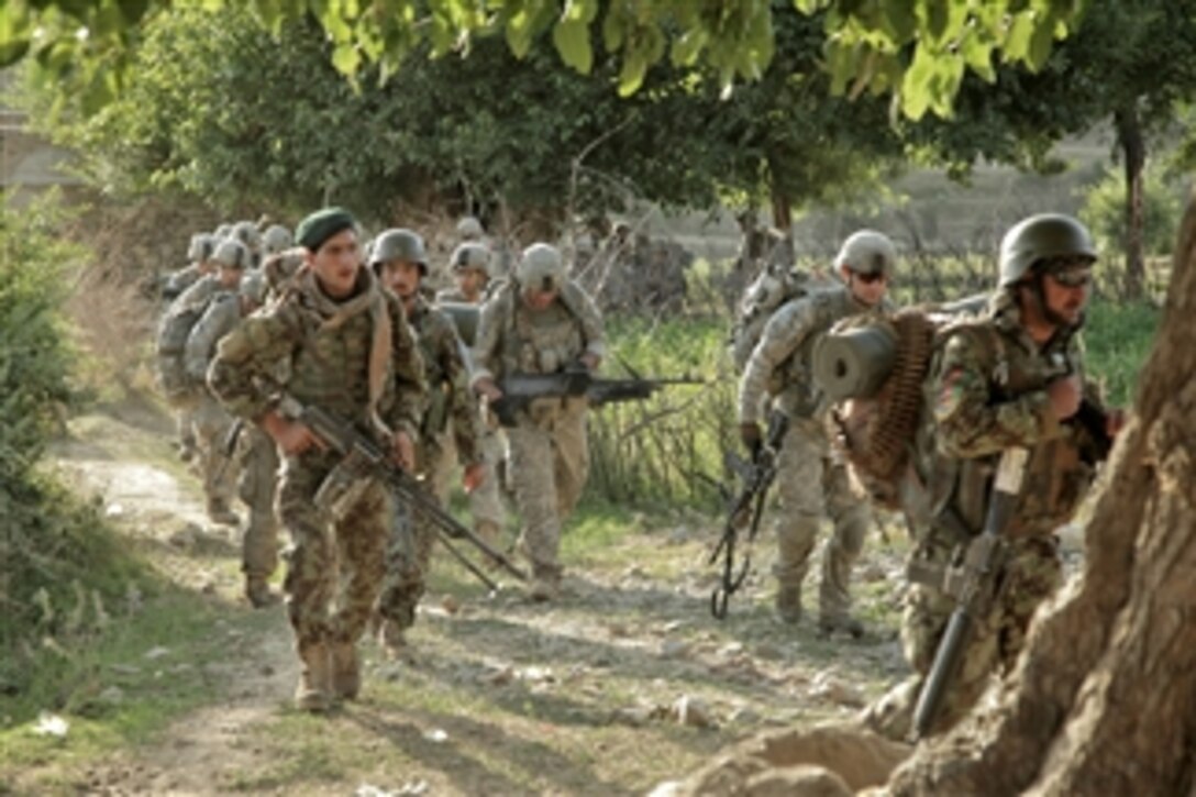 Afghan soldiers and their U.S. counterparts march toward Gerekheyl village during an early morning patrol in Nangarhar province, Afghanistan, on June 14, 2011.  The soldiers are with Bravo Troop, 1st Squadron, 61st Cavalry Regiment, 4th Brigade Combat Team, 101st Airborne Division.  